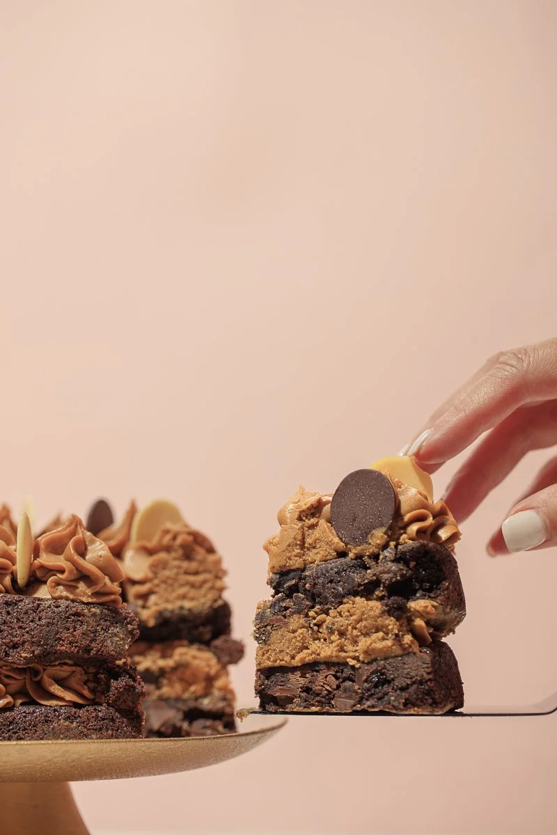 Hand serving a slice of chocolate layer cake, hand model pastry photography