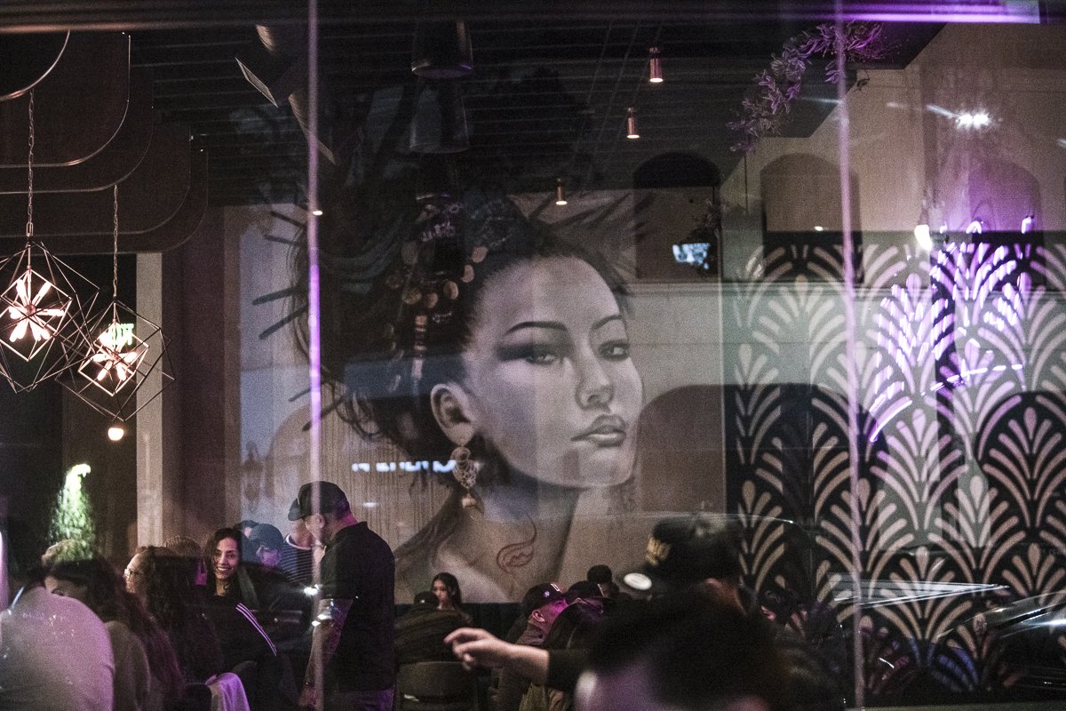 Busy restaurant dining room at night with a large mural, shot during service - restaurant interior photographer