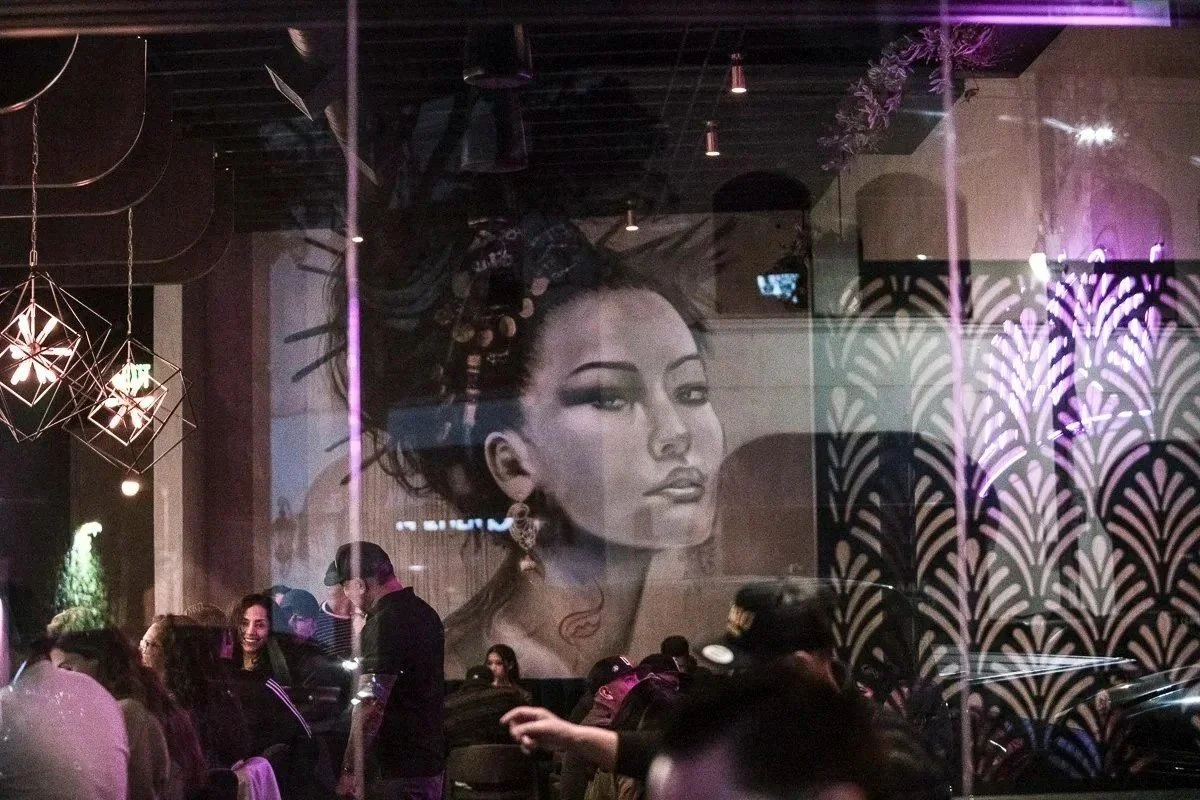 Restaurant lounge with a large mural of a woman's face and patterned screens - Orange County restaurant photographer