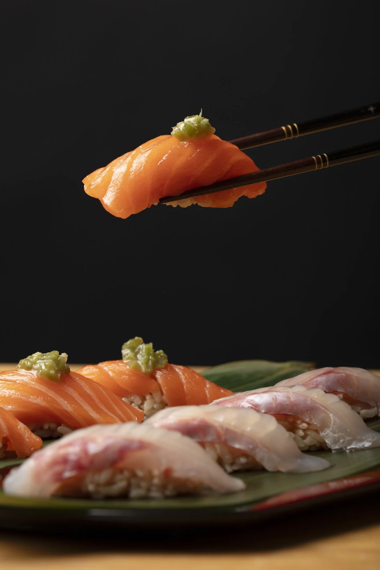 chopsticks-lifting-salmon-nigiri-over-platter.jpg