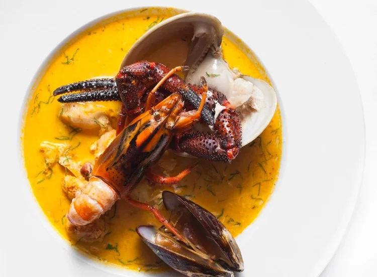 Seafood stew with mussels and clams in saffron broth - soft diffused food photography