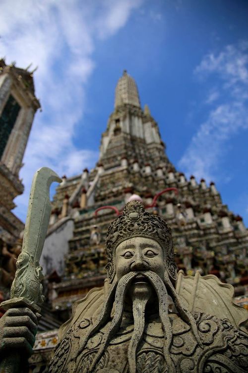 Stone guardian at Wat Arun in Bangkok by Drew Redmond