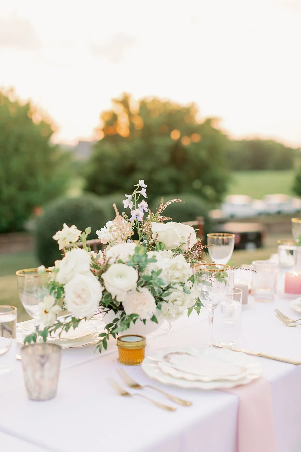 This garden-inspired reception features floral hues of blush, ivory, cream, pink, and hints of French blue along with centerpieces of pink roses, peonies, garden roses, blue delphinium, ranunculus, spirea and hydrangea. Designed by Rosemary & Finch i