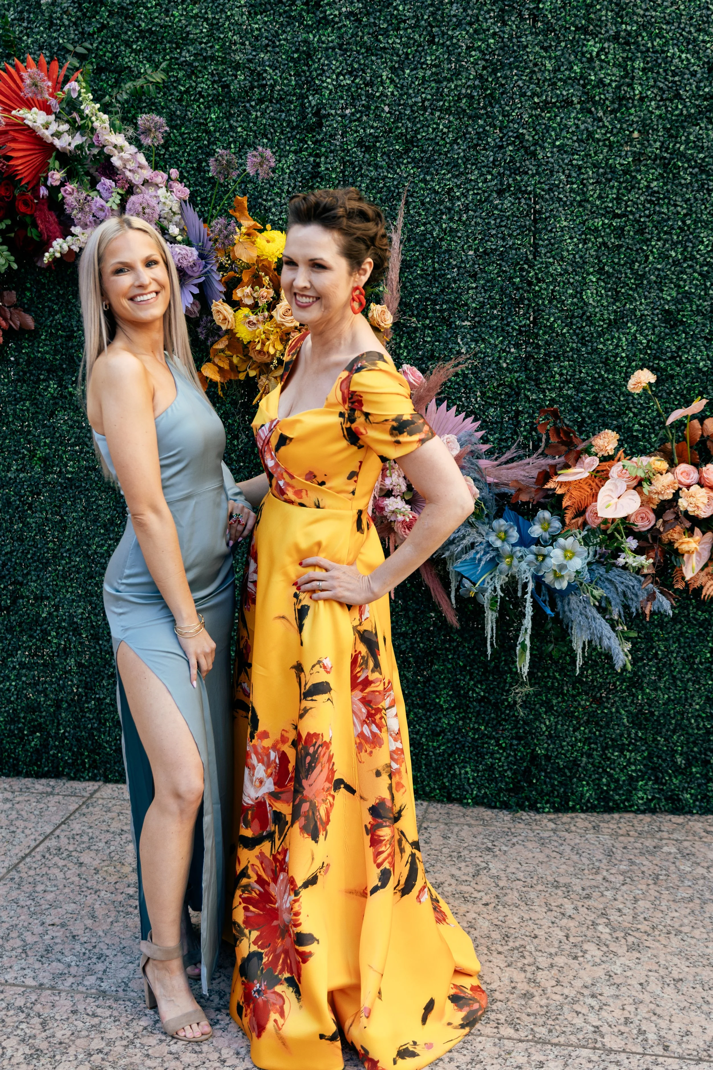 Modern colorful photo wall with rainbow hues of red, purple, yellow, blue, and orange. Comprised of roses, hydrangeas, tulips, snapdragons, dried palms, and anthurium. Designed by Rosemary and Finch in Nashville, TN.
