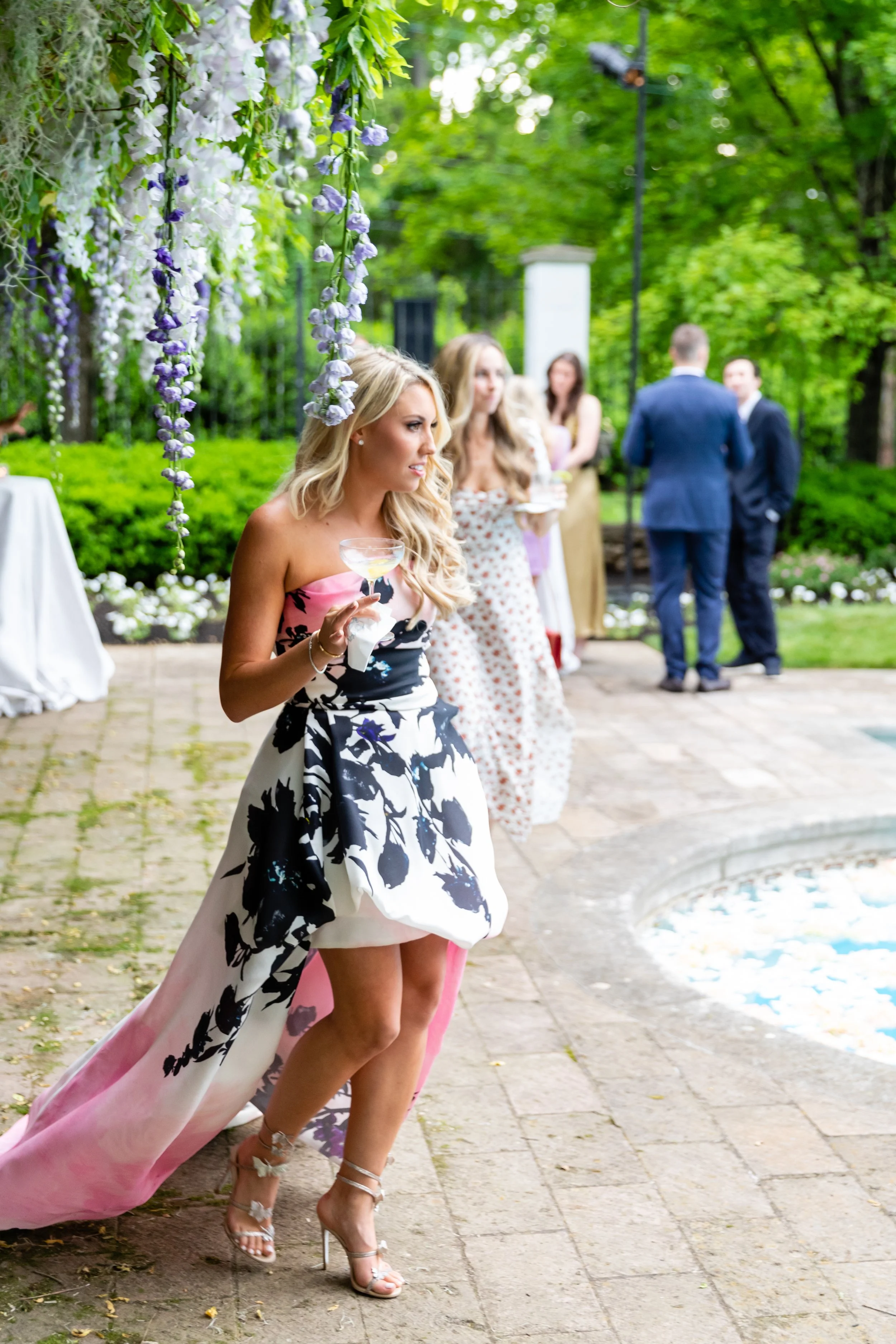 Bridgerton inspired engagement party at a private home in Nashville, TN with pastel candles and flowers floating in the pool with wisteria and delphinium growing over the bar. Nashville wedding floral designer, Rosemary & Finch.