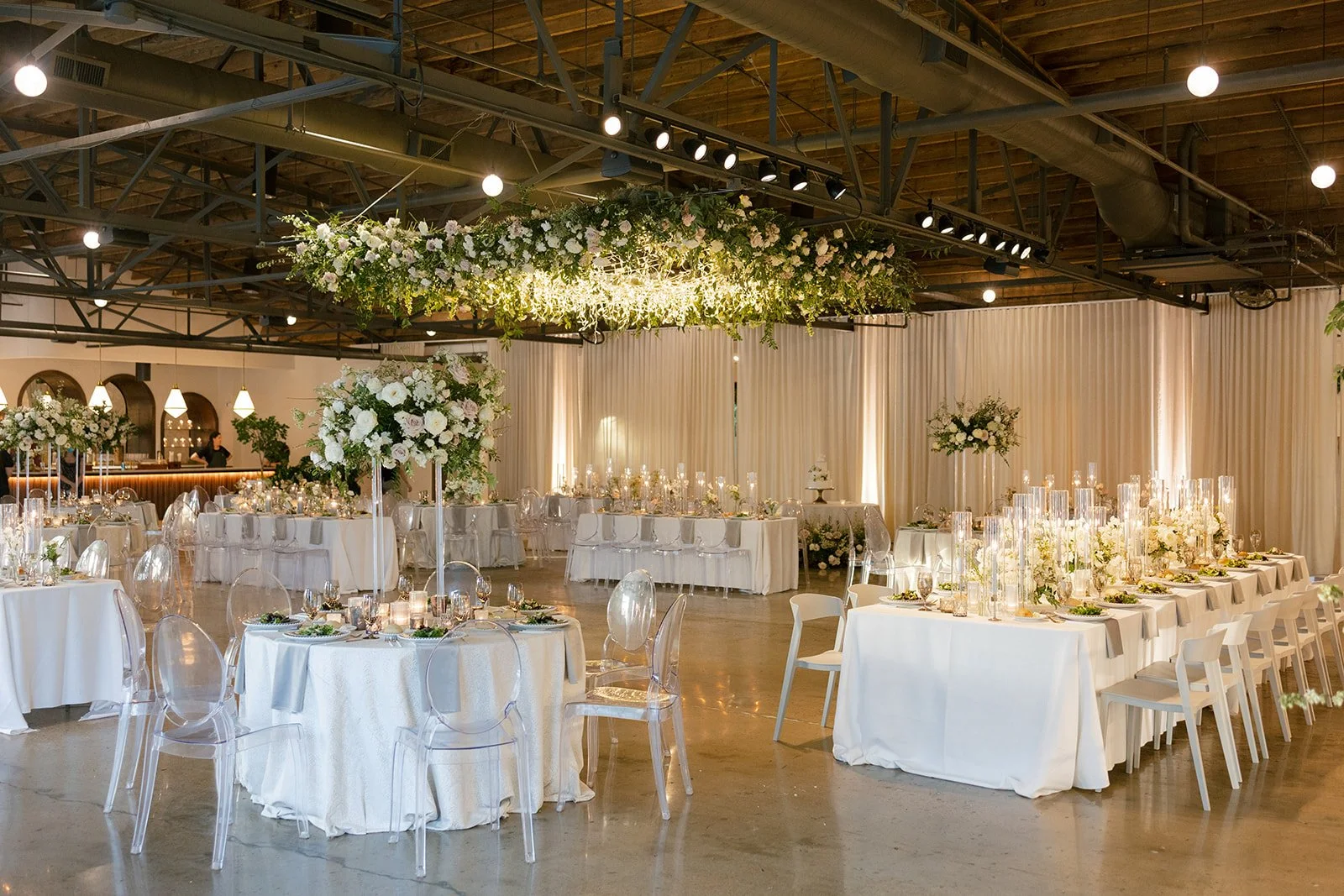 Lush floral chandelier lights up the dance floor with florals of petal heavy roses, ranunculus, lisianthus, delphinium, and dark greenery in hues of white, cream, and blush. Designed by Rosemary and Finch in Nashville, TN.