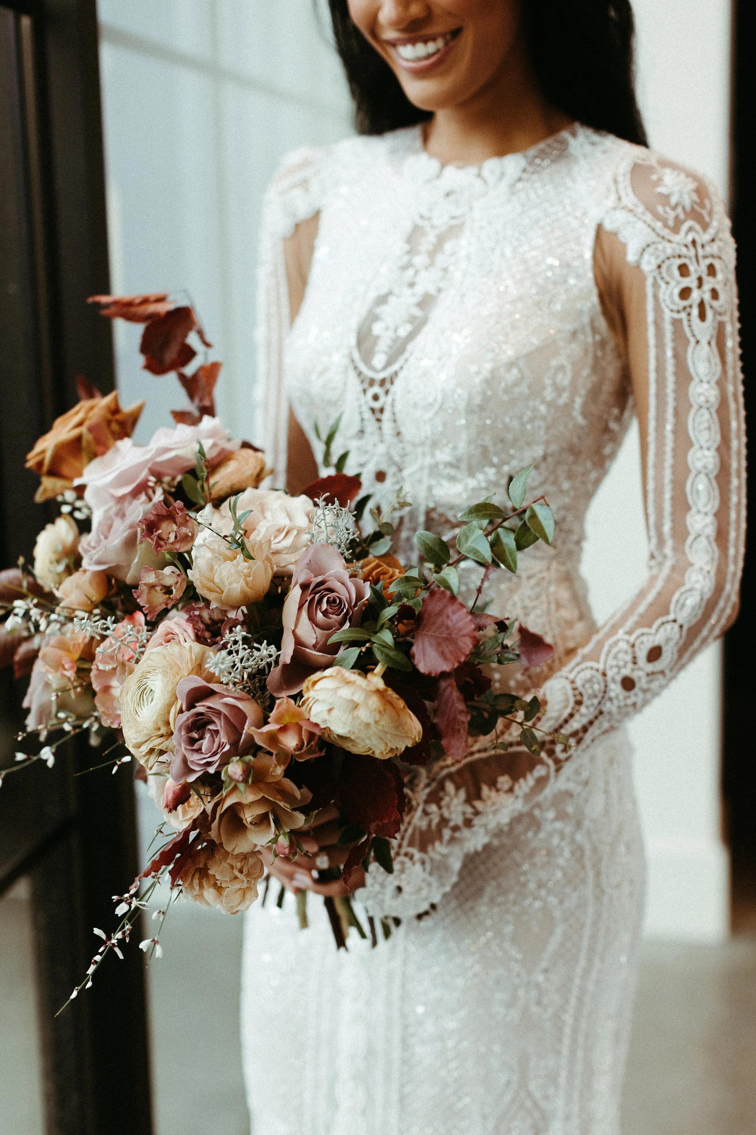 This elegant bridal bouquet brought hues of mauve, dusty pink, cream, burgundy, and terra cotta to this winter wedding. Lush with petal heavy roses, ranunculus, spray roses, copper beech, and greenery. Designed by Rosemary and Finch in Nashville, TN.