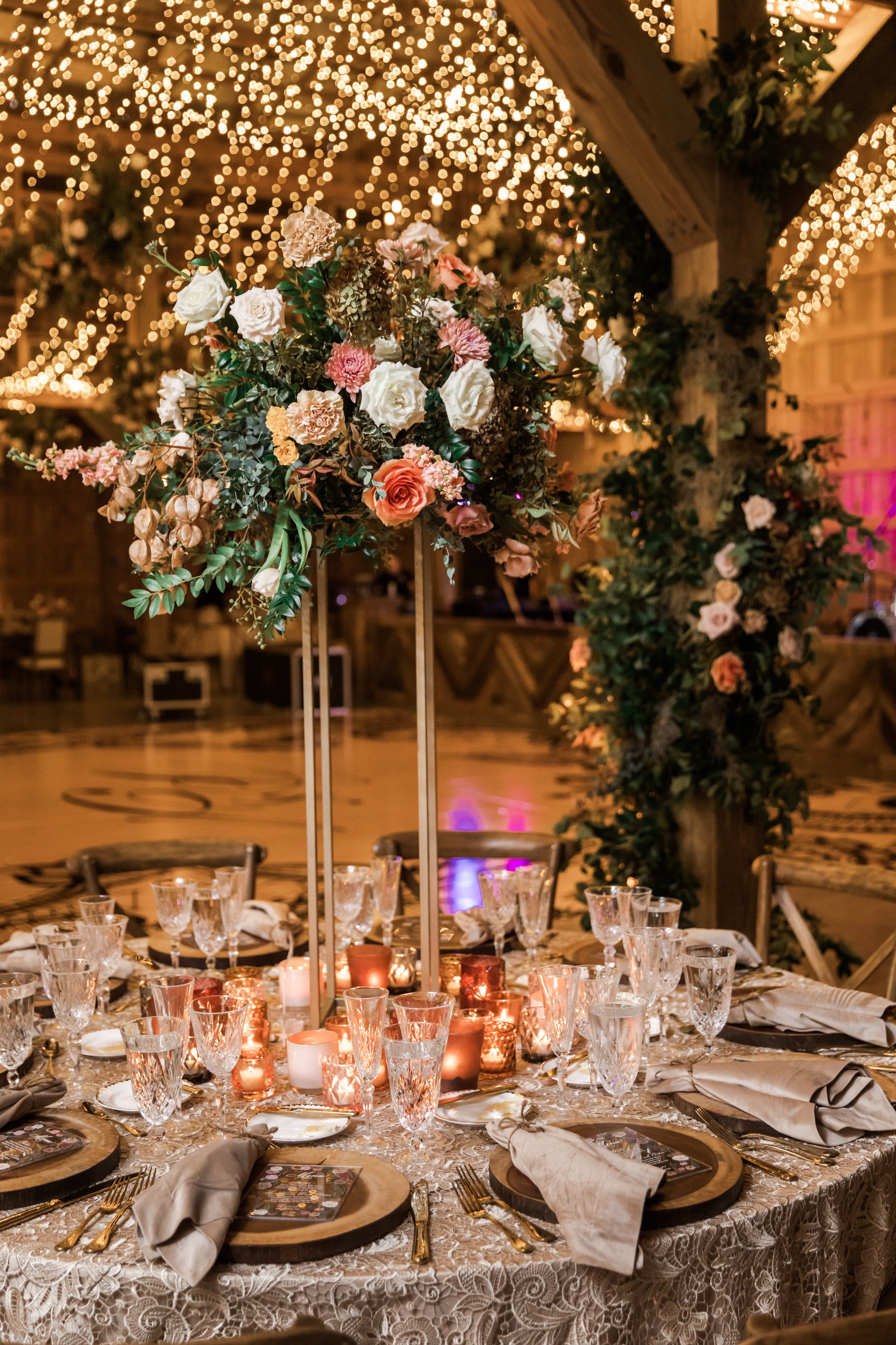 Gorgeous autumnal elevated centerpieces featuring garden roses, ranunculus, and dahlias are adorned with fairy ring candles creating hues of copper, blush, terra cotta, and yellow. Designed by Rosemary and Finch in Nashville, TN.