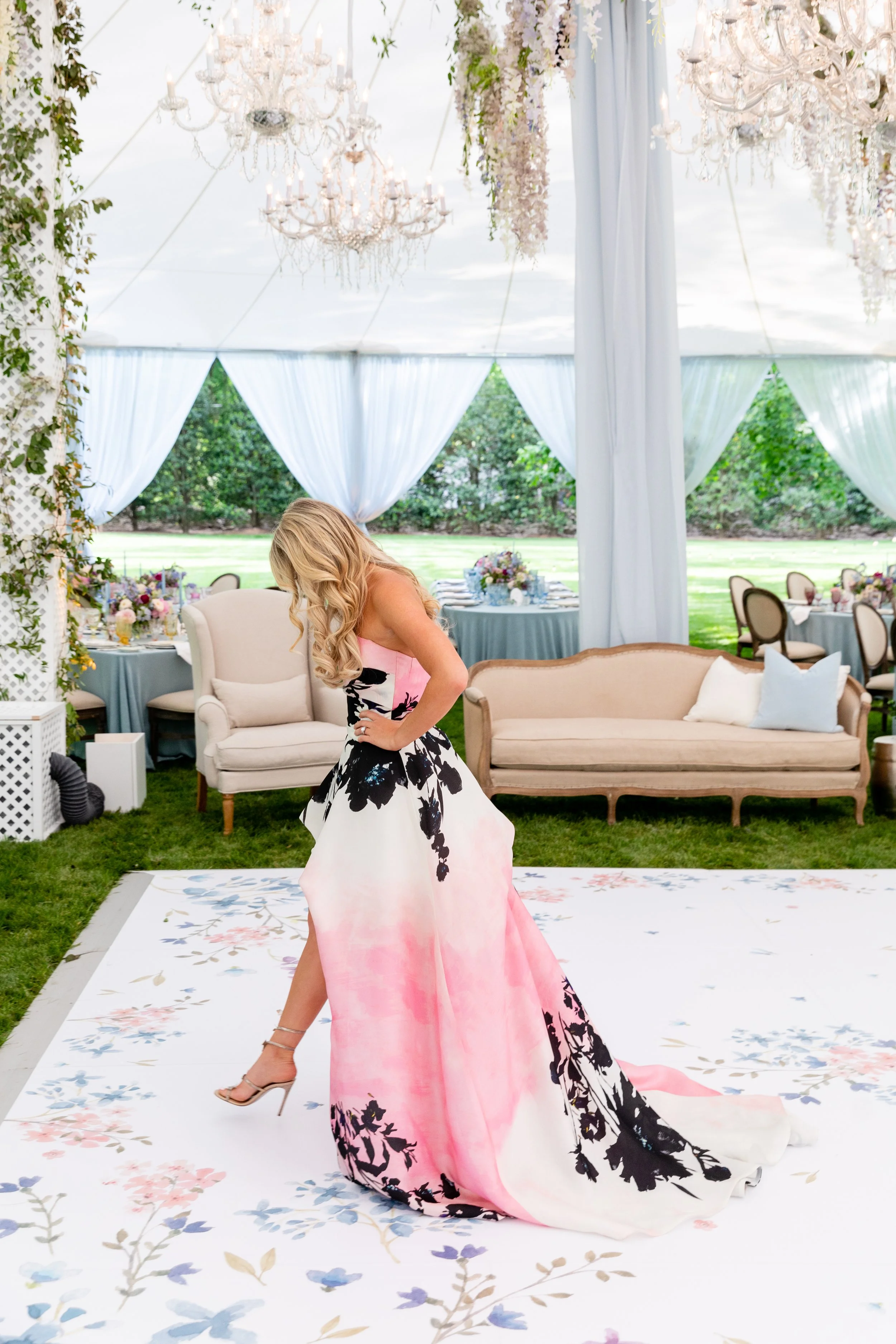 Growing, fresh floral installations with blush garden roses, lavender delphinium, wisteria, globe allium, and vines and greenery for a tented Bridgerton inspired engagement party at a private home in Nashville, TN. Flower by Tennessee based wedding f