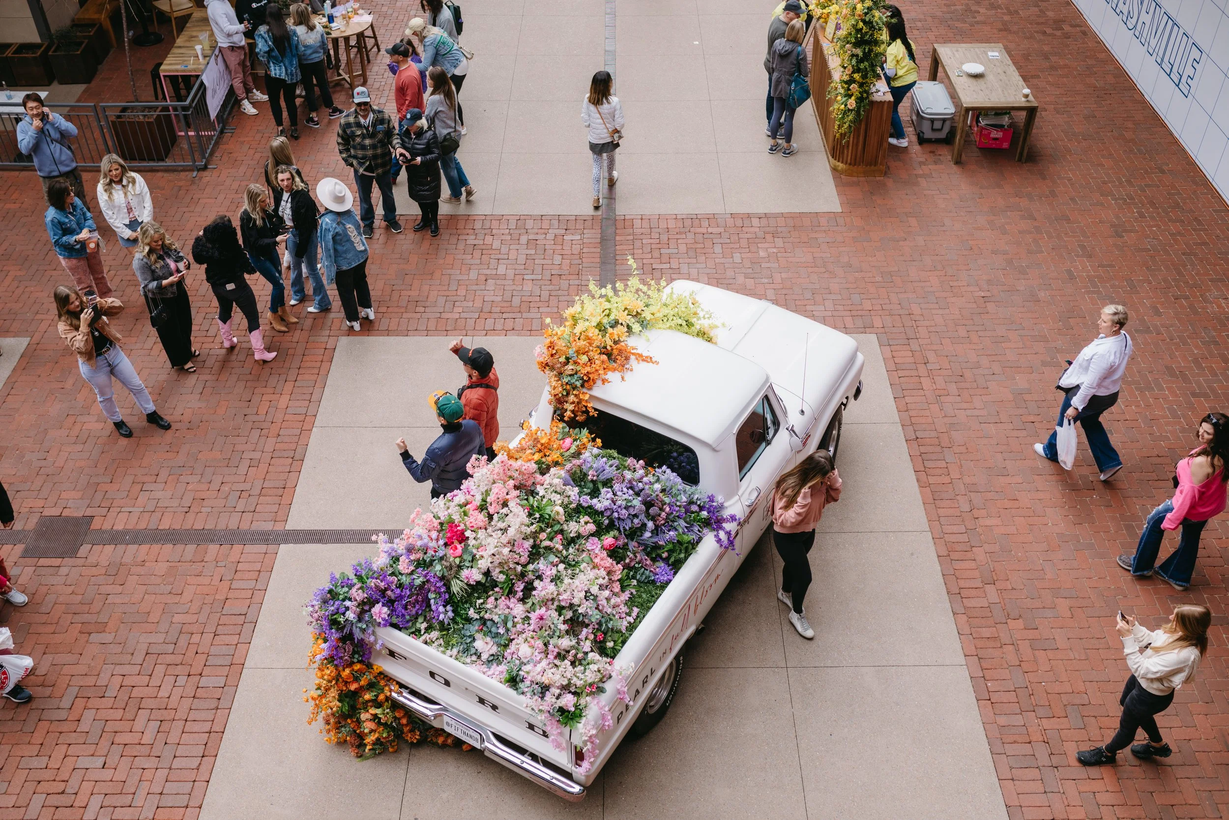 Cheerful pickup truck installation composed of silk floral hues in pink, magenta, lavender, coral, orange, yellow, and mixed greens bring to life this spring Fifth + Broadway event in Nashville, TN. Design by Rosemary and Finch.