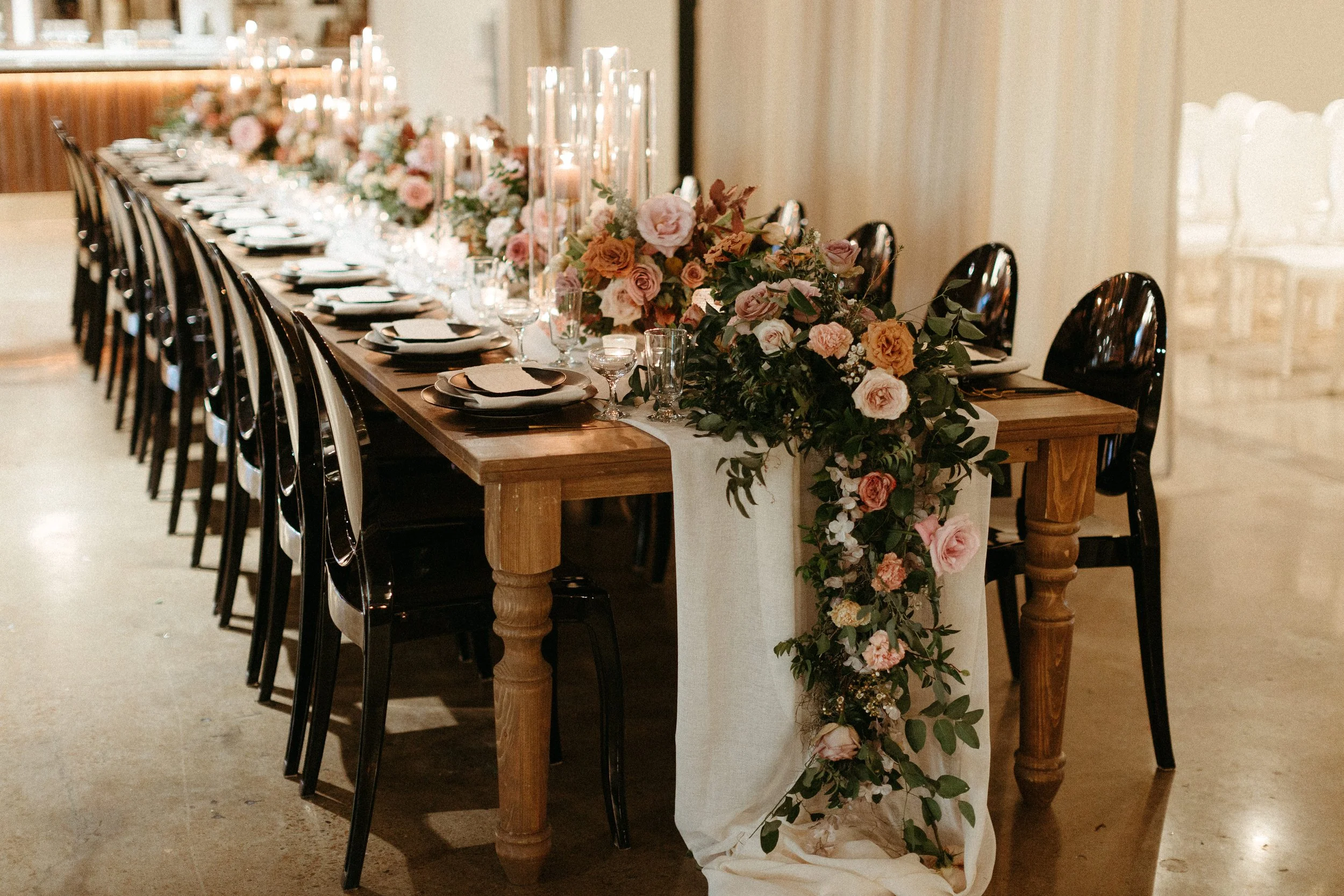 Beautiful floral cascades decorate the tables of this art deco wedding. Petal heavy roses, dried branches, and greenery bring floral hues of terra cotta, dusty pink, burgundy, and sage green. Designed by Rosemary and Finch in Nashville, TN.