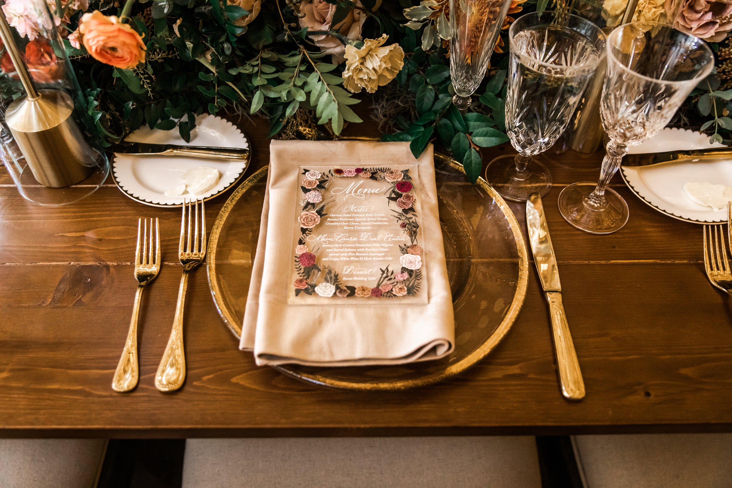 Stunning floral cascades line tables of this fall reception with terra cotta, blush, yellow hues, and taupe taper candles. Florals featuring dahlias, roses, and rain tree pods create lush arrangements. Designed by Rosemary and Finch in Nashville, TN.
