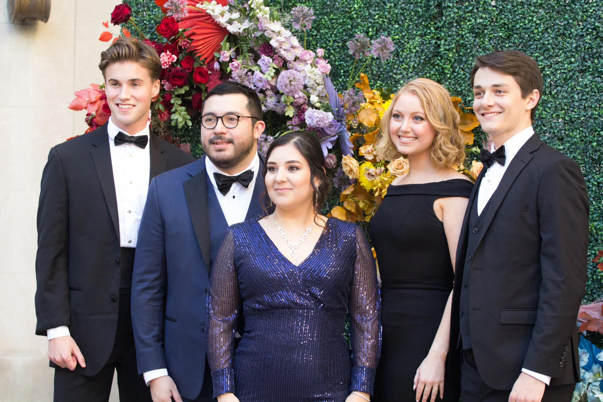 Modern colorful photo wall with rainbow hues of red, purple, yellow, blue, and orange. Comprised of roses, hydrangeas, tulips, snapdragons, dried palms, and anthurium. Designed by Rosemary and Finch in Nashville, TN.