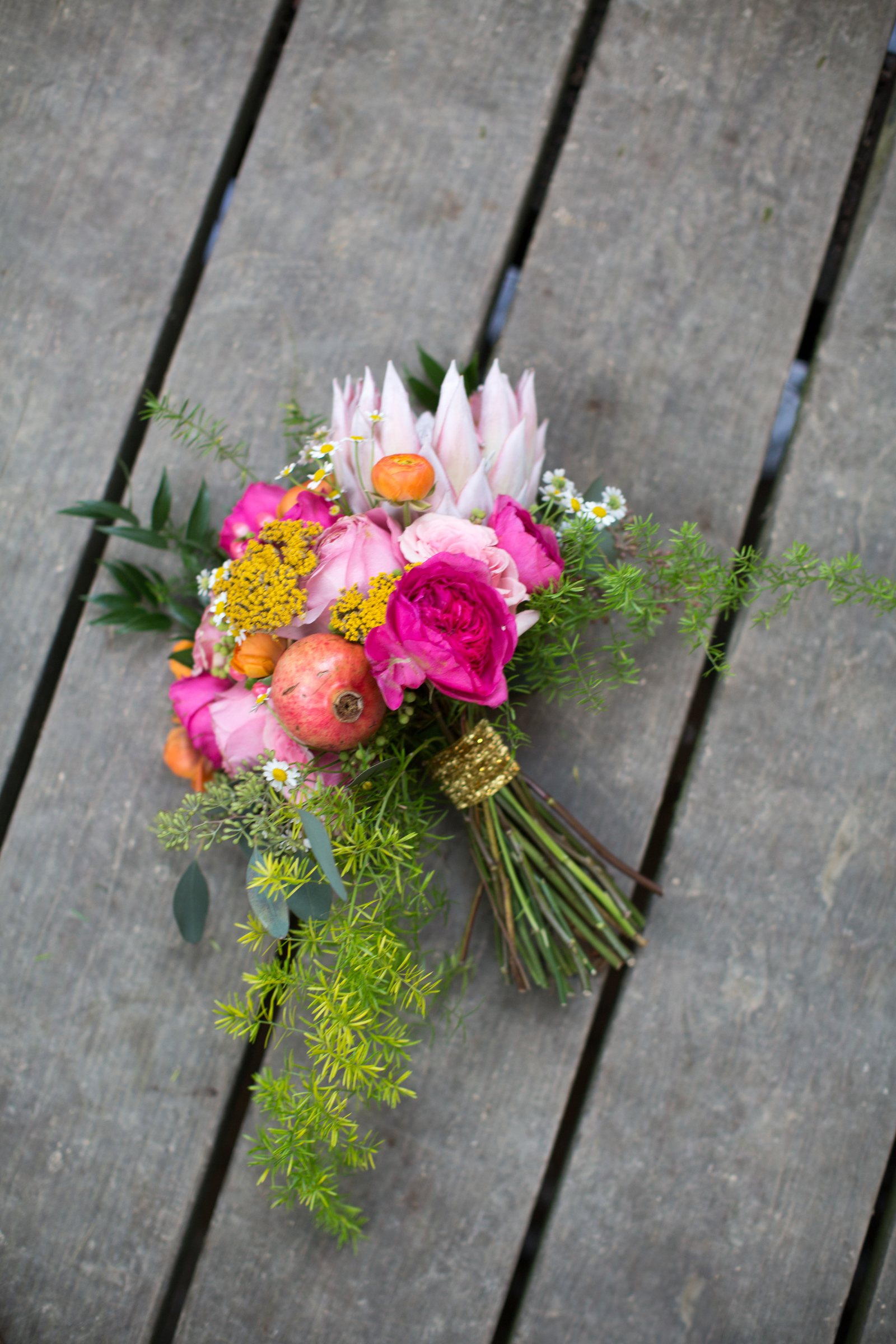 Bright bridal bouquet with a pomegranate and king protea