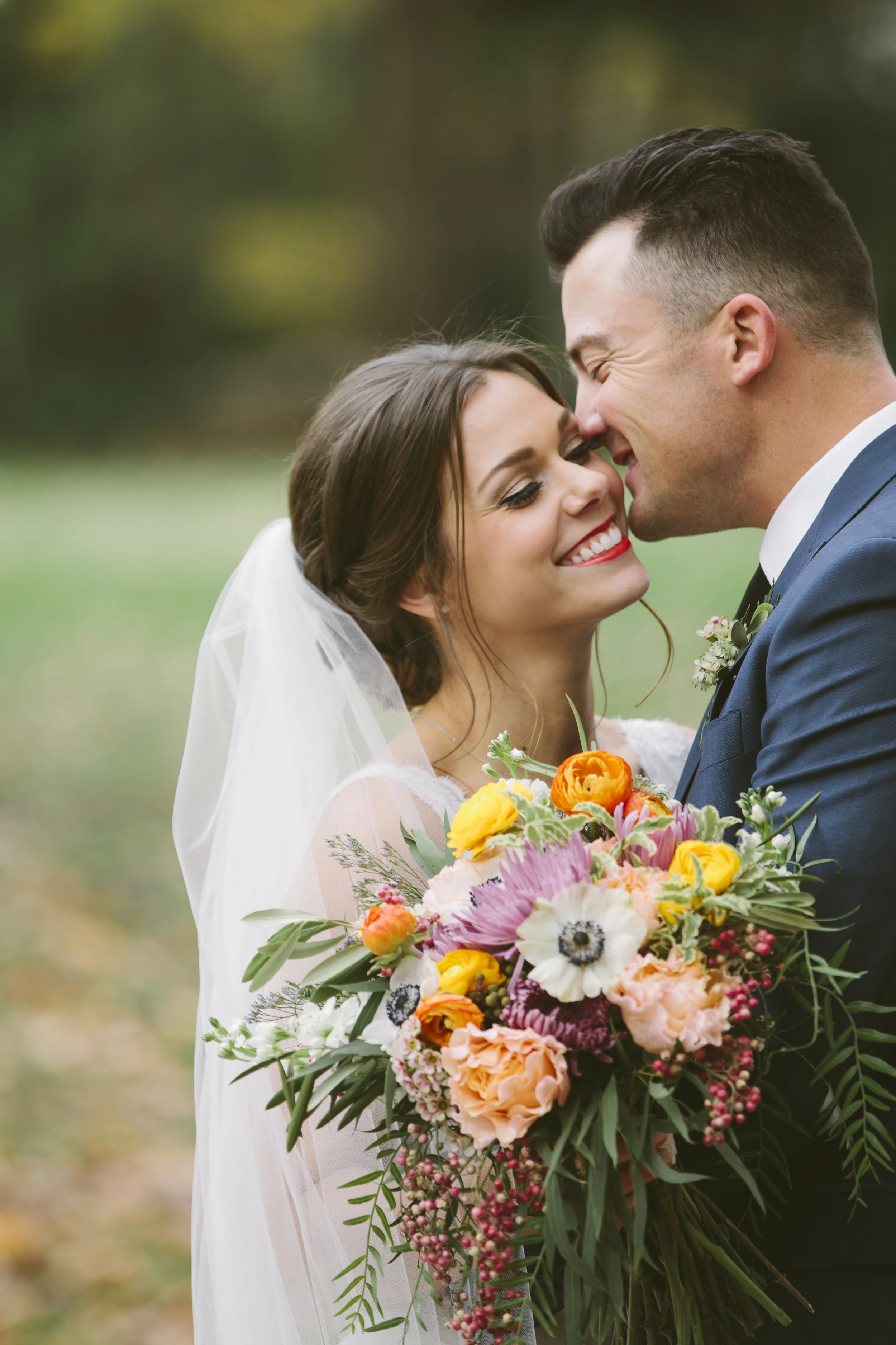 Bright bridal bouquet with garden roses, ranunculus, anemones, and pepperberries // Nashville Wedding Florist