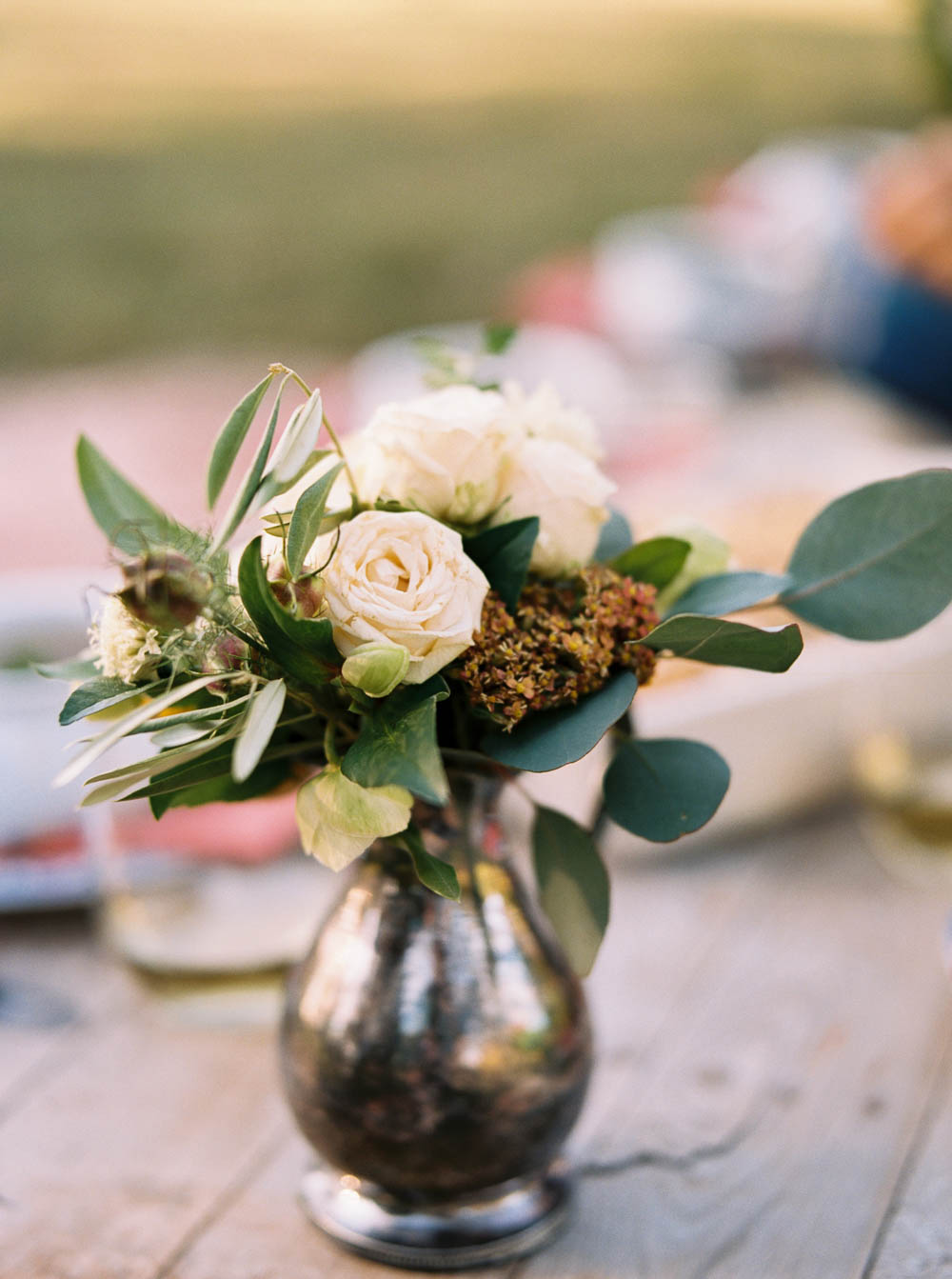 Silver pitcher filled with floral arrangement