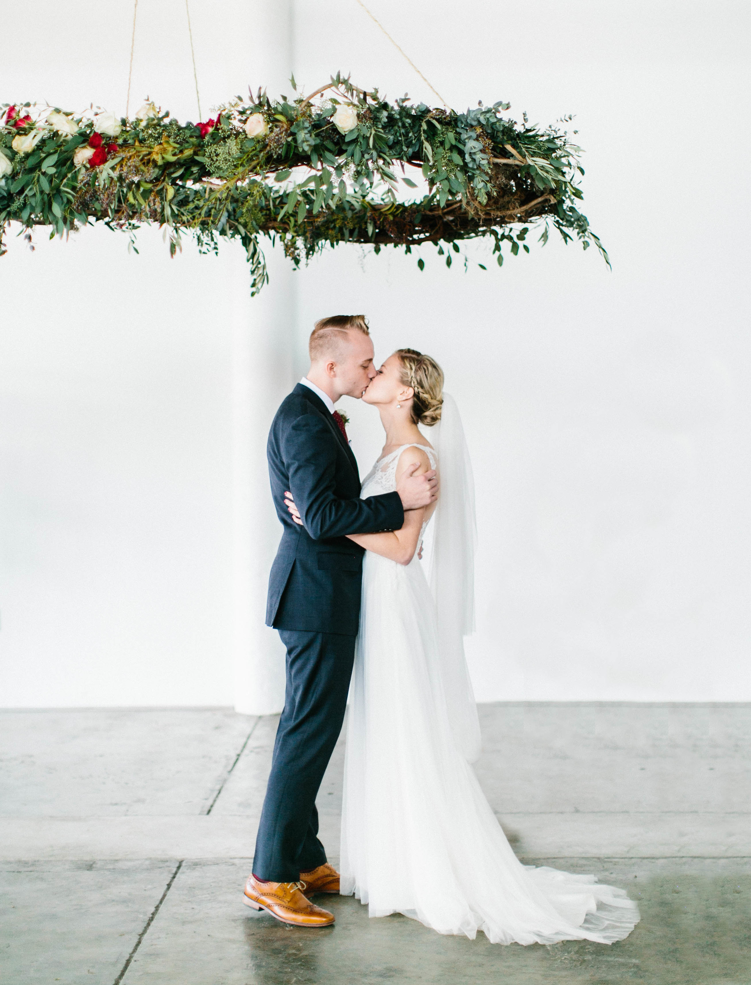 First Kiss under suspended floral wreath // Destination Wedding Florals