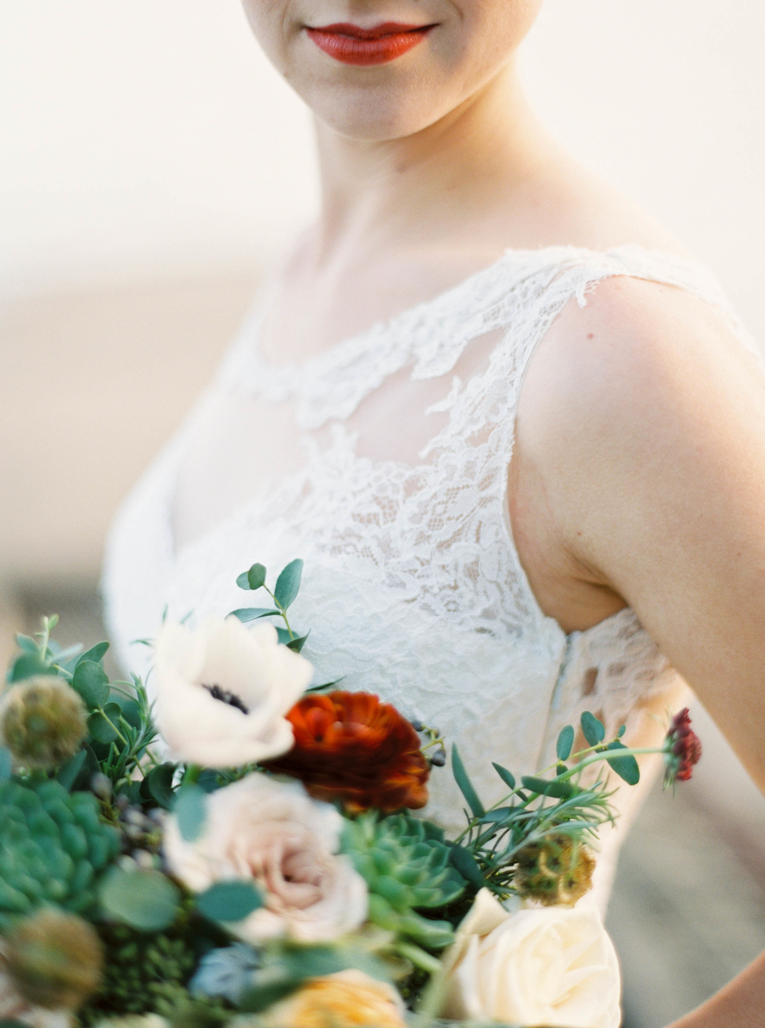 Loose, untamed bridal bouquet with olive branches, ranunculus, and succulents