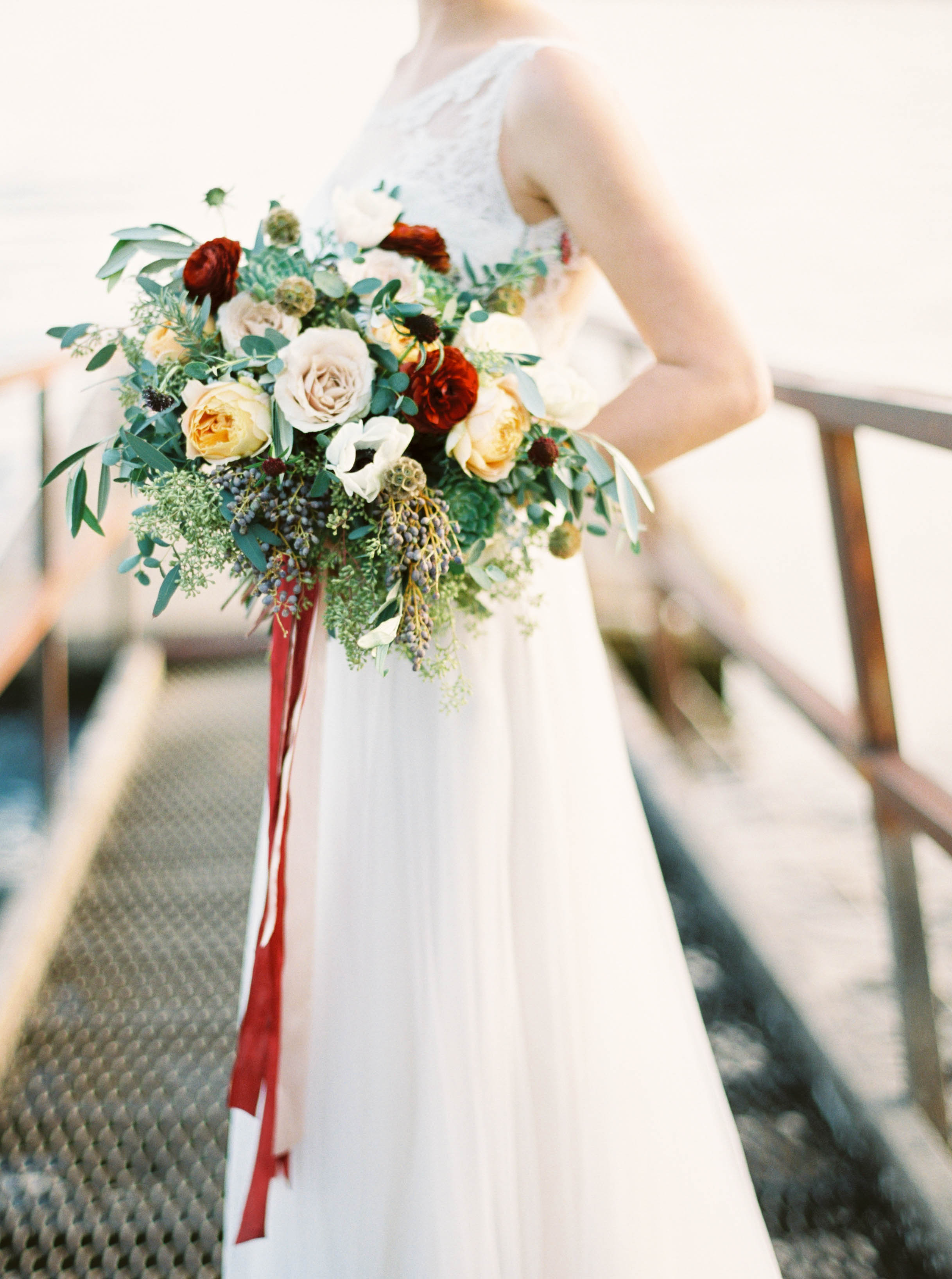 Loose, trailing bouquet with garden roses, ranunculus, and olive branches // Destination Floral Design