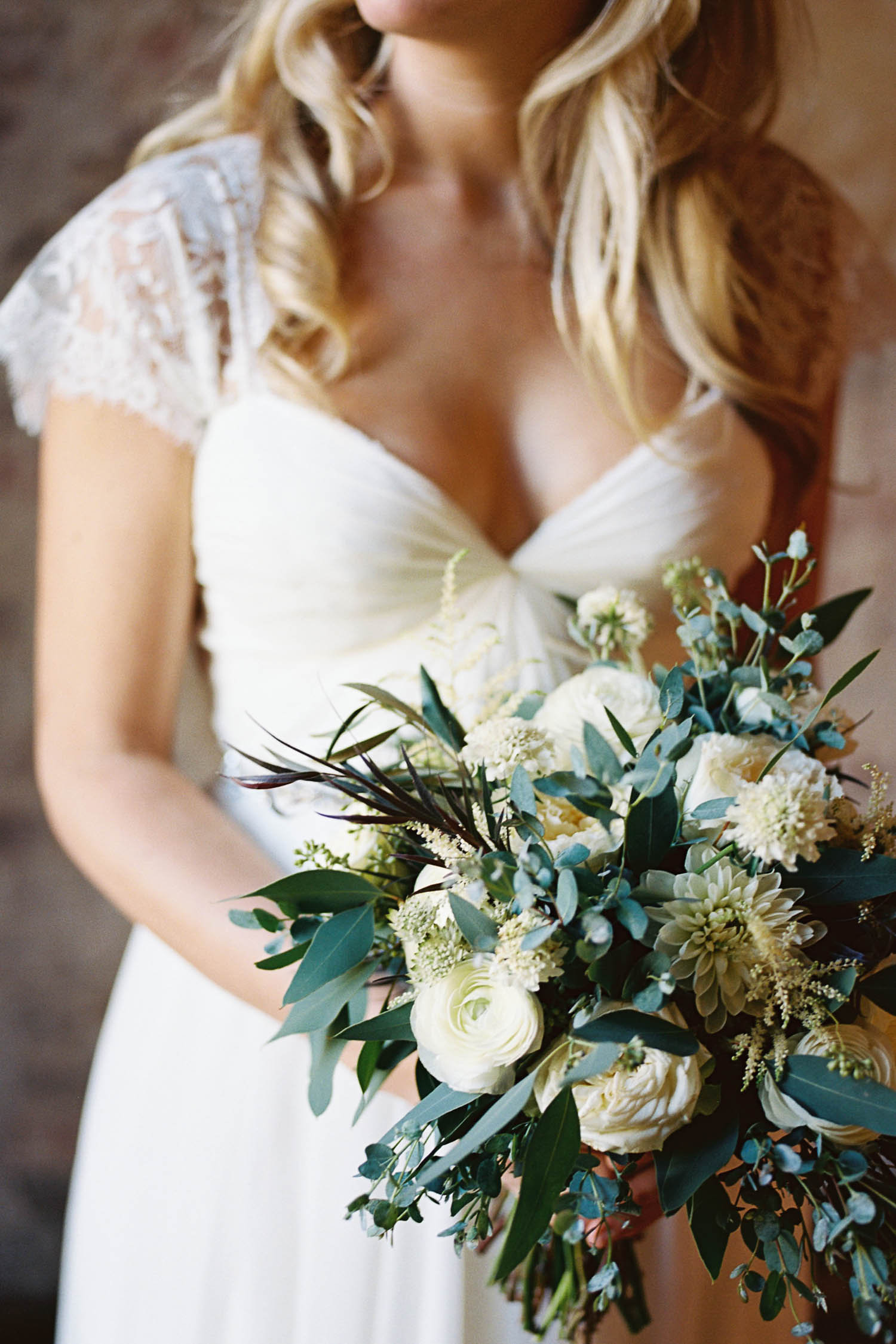Loose, natural bridal bouquet of greenery and ivory flowers