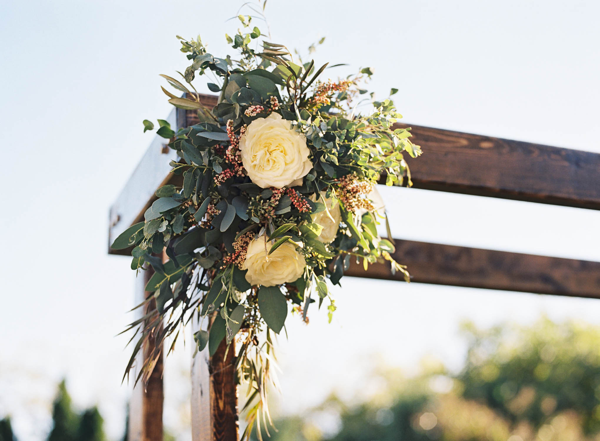 Rustic wooden chuppah with floral accents