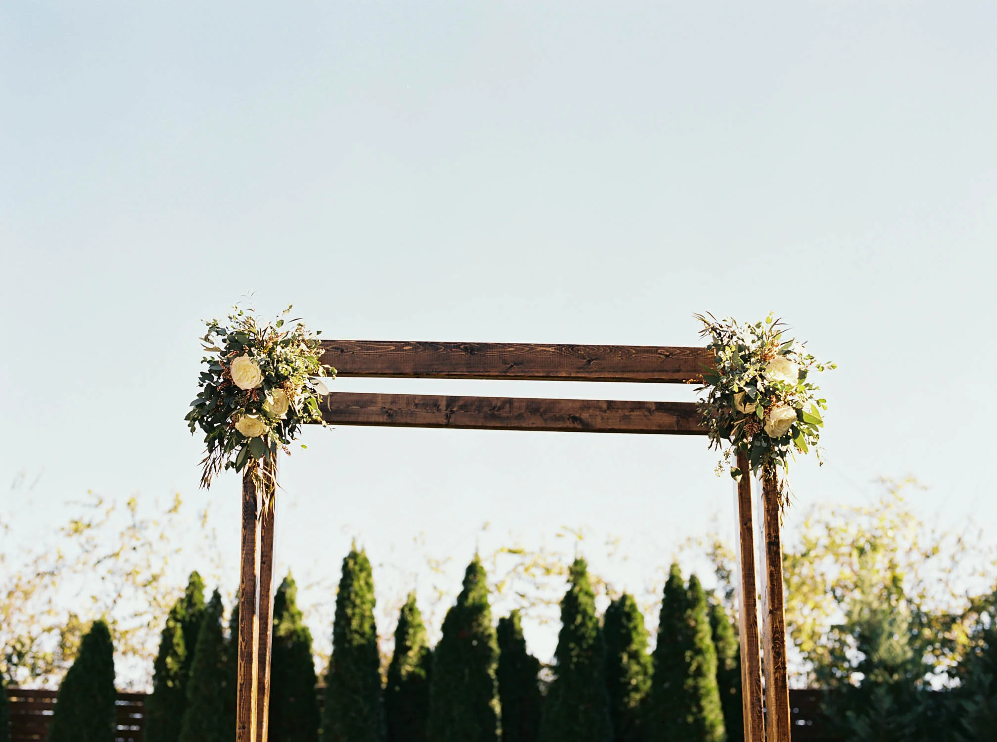 Simple wooden chuppah with floral sprays // Nashville Wedding Florist