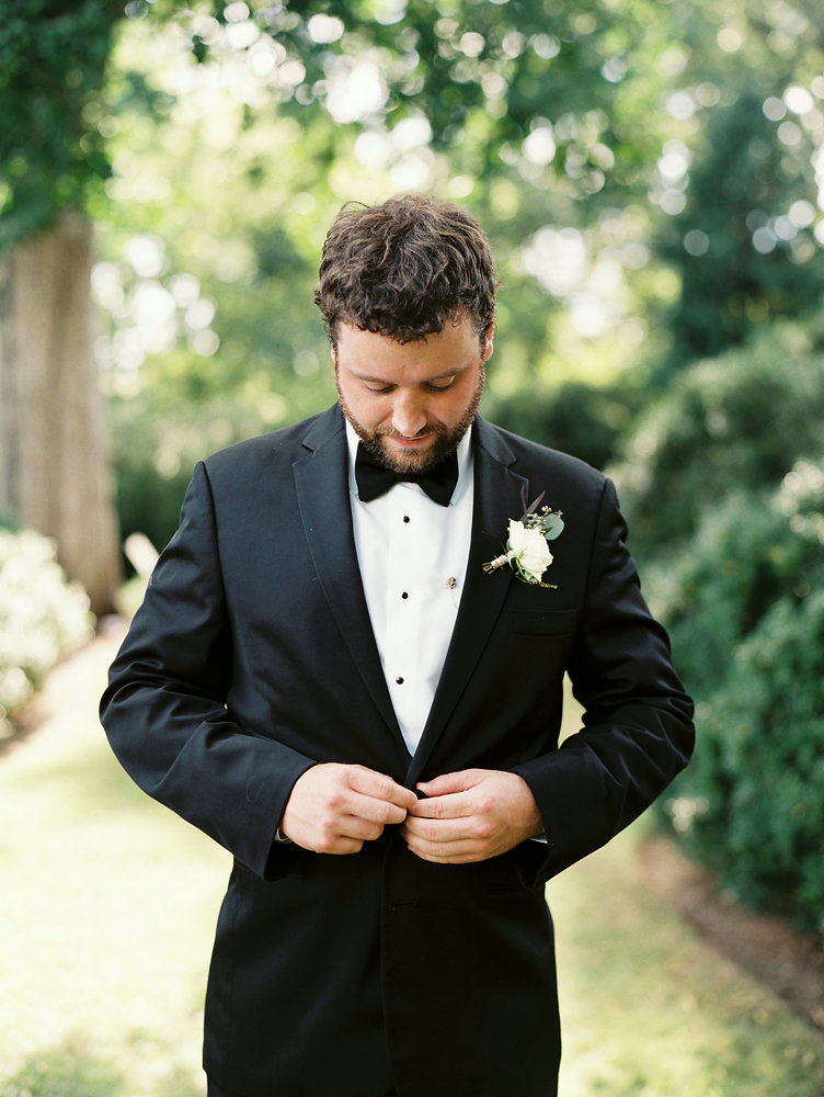 Groom in tux with white and greenery boutonniere // Nashville Floral Design