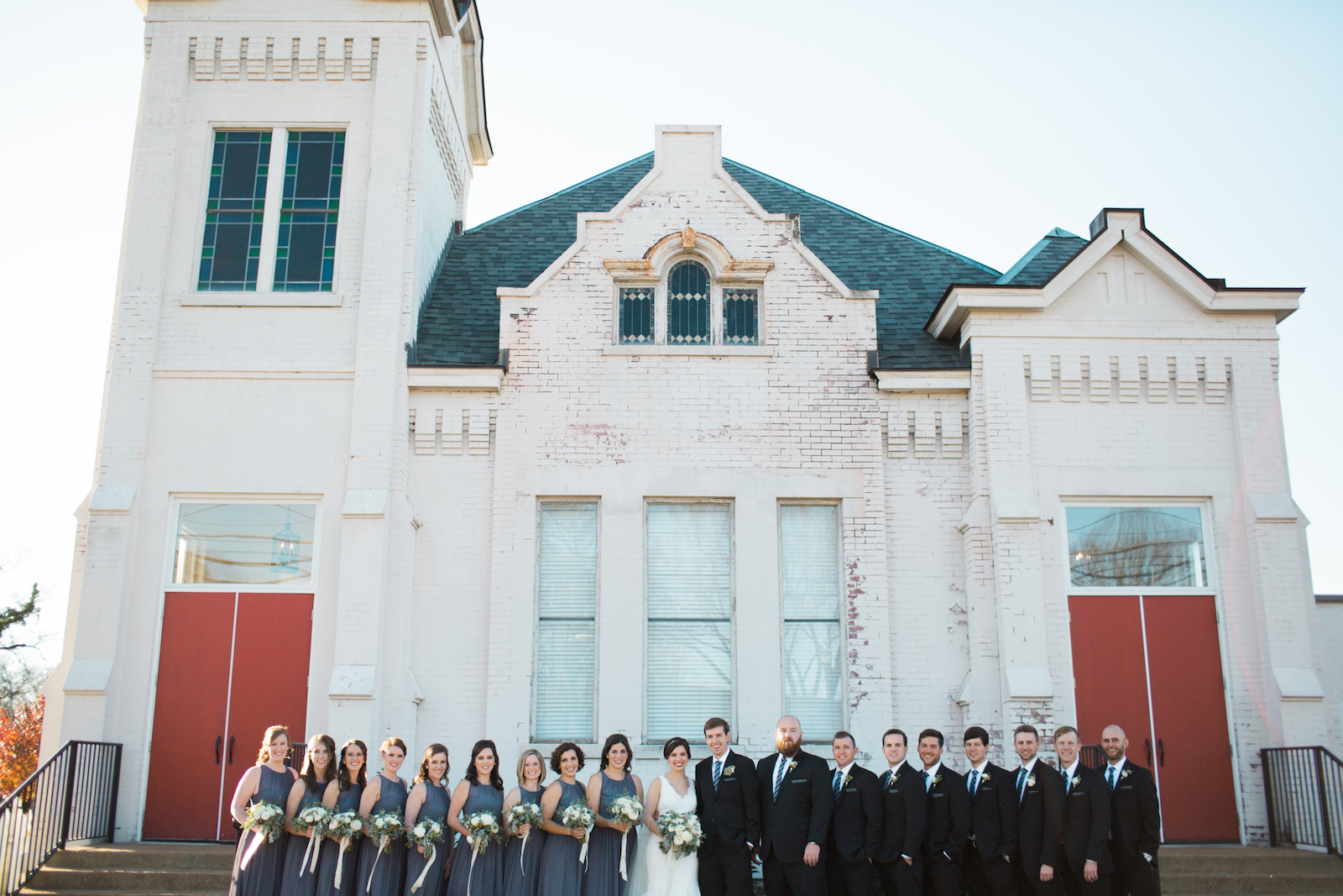 Bridal party in front of little white church with red doors // Southern Wedding Florist