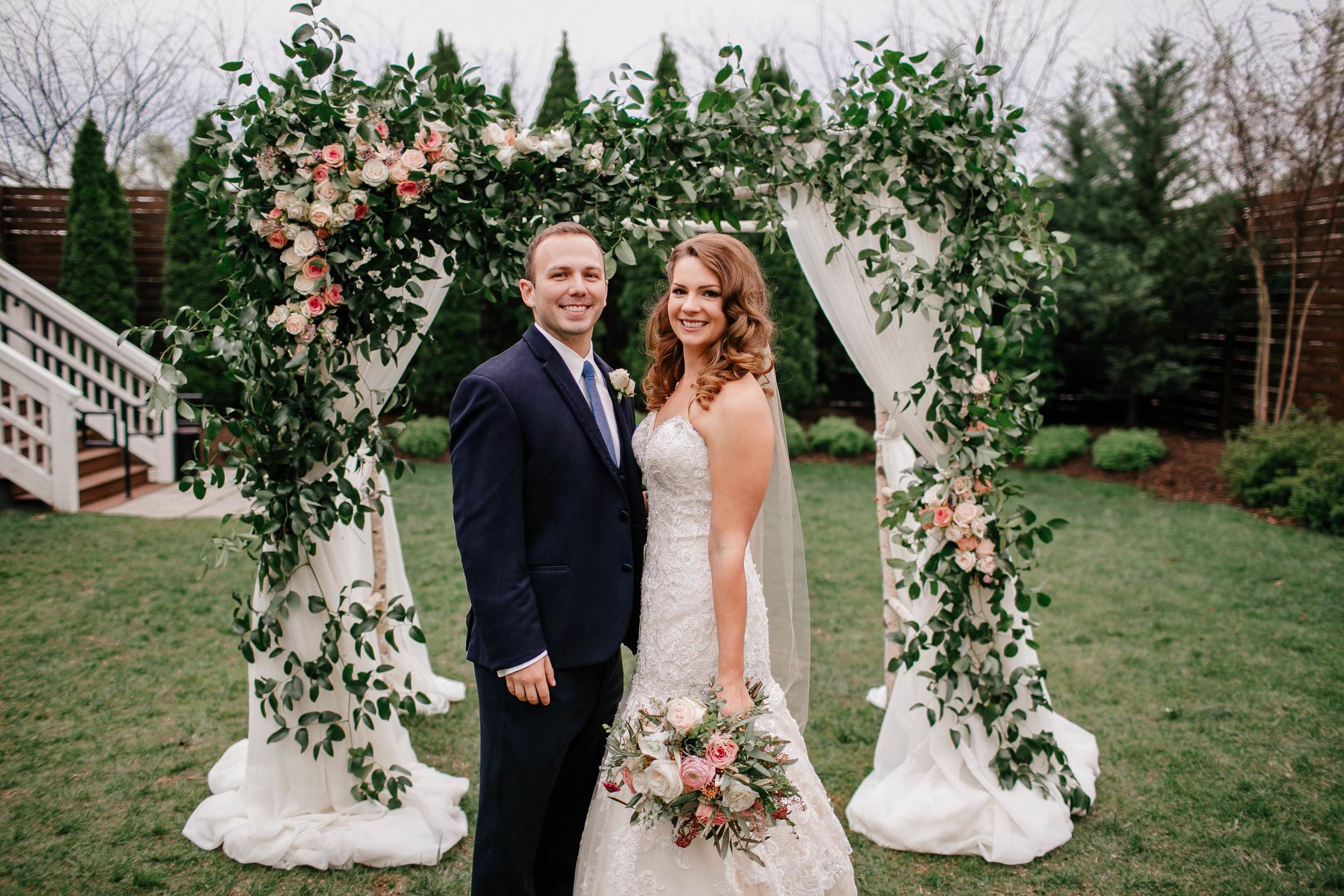 Loose, natural chuppah decor of lush greenery and roses // Nashville Wedding Flowers
