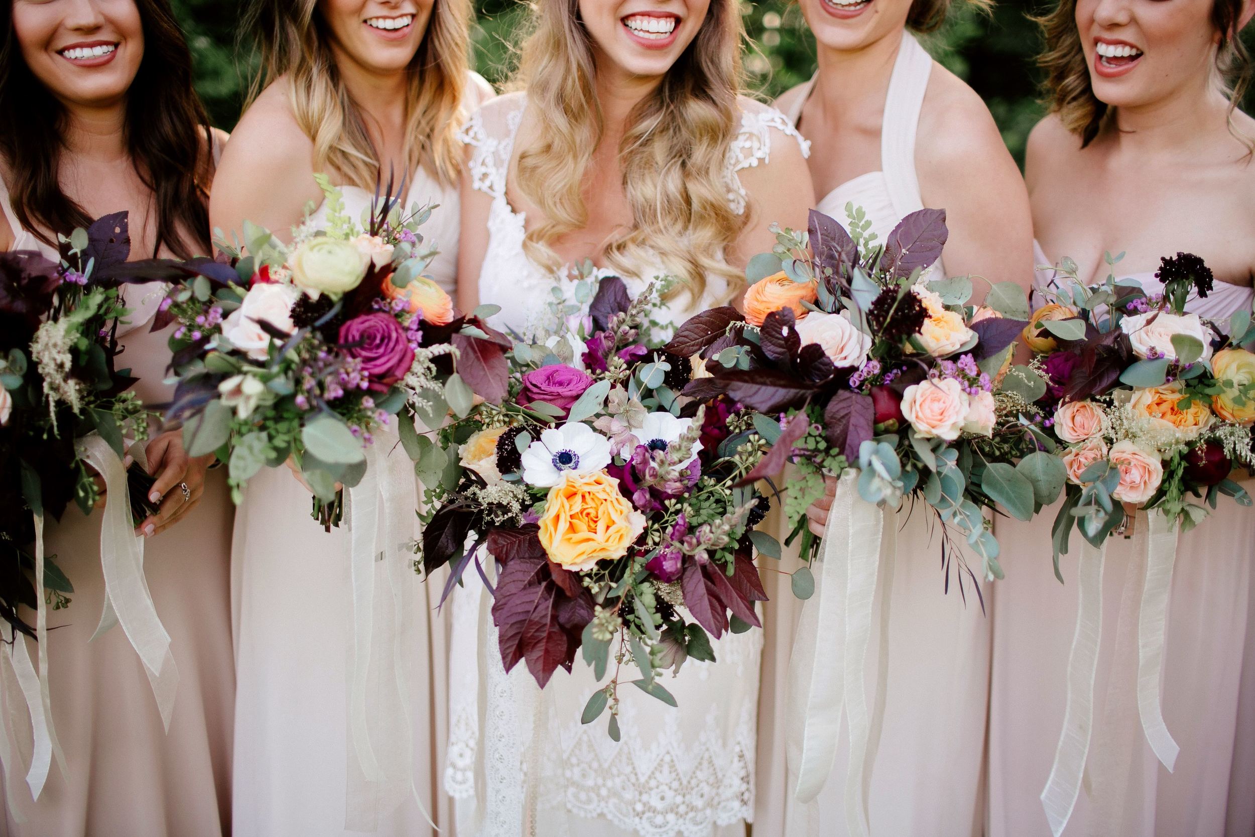 Bohemian bridal party with florals in lavender, peach, and maroon