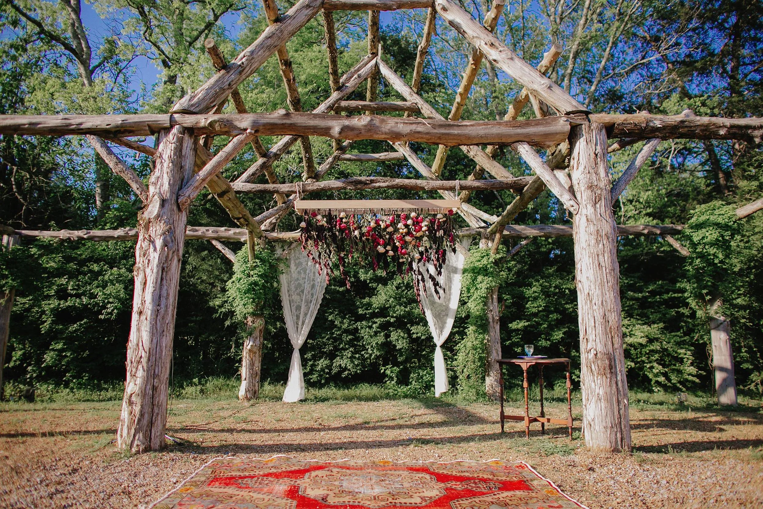 Bohemian fiesta wedding ceremony backdrop with gorgeous rug and floral installation // Nashville Wedding Florist