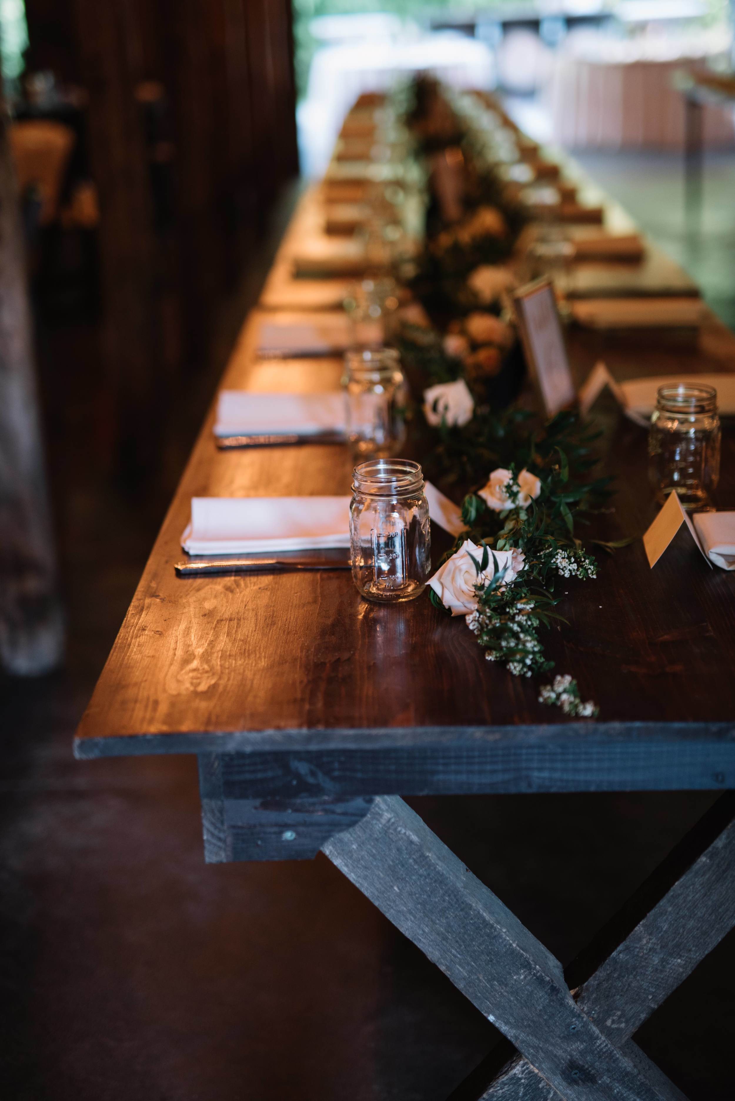 Lush greenery garland on farm tables with floral accents // Nashville Wedding Florist
