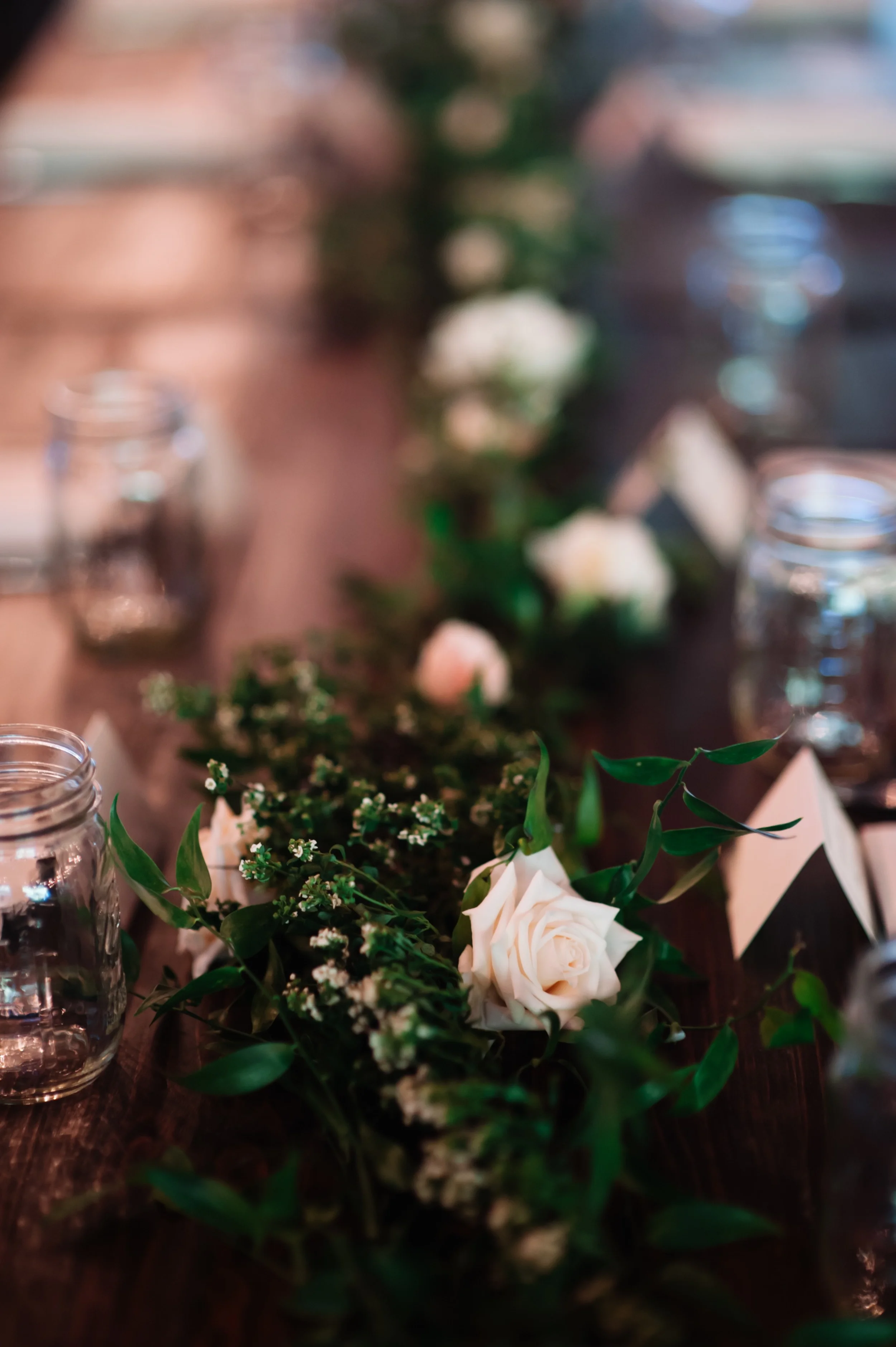 Blush, ivory, and greenery floral garlands on farm tables // Nashville Barn Wedding