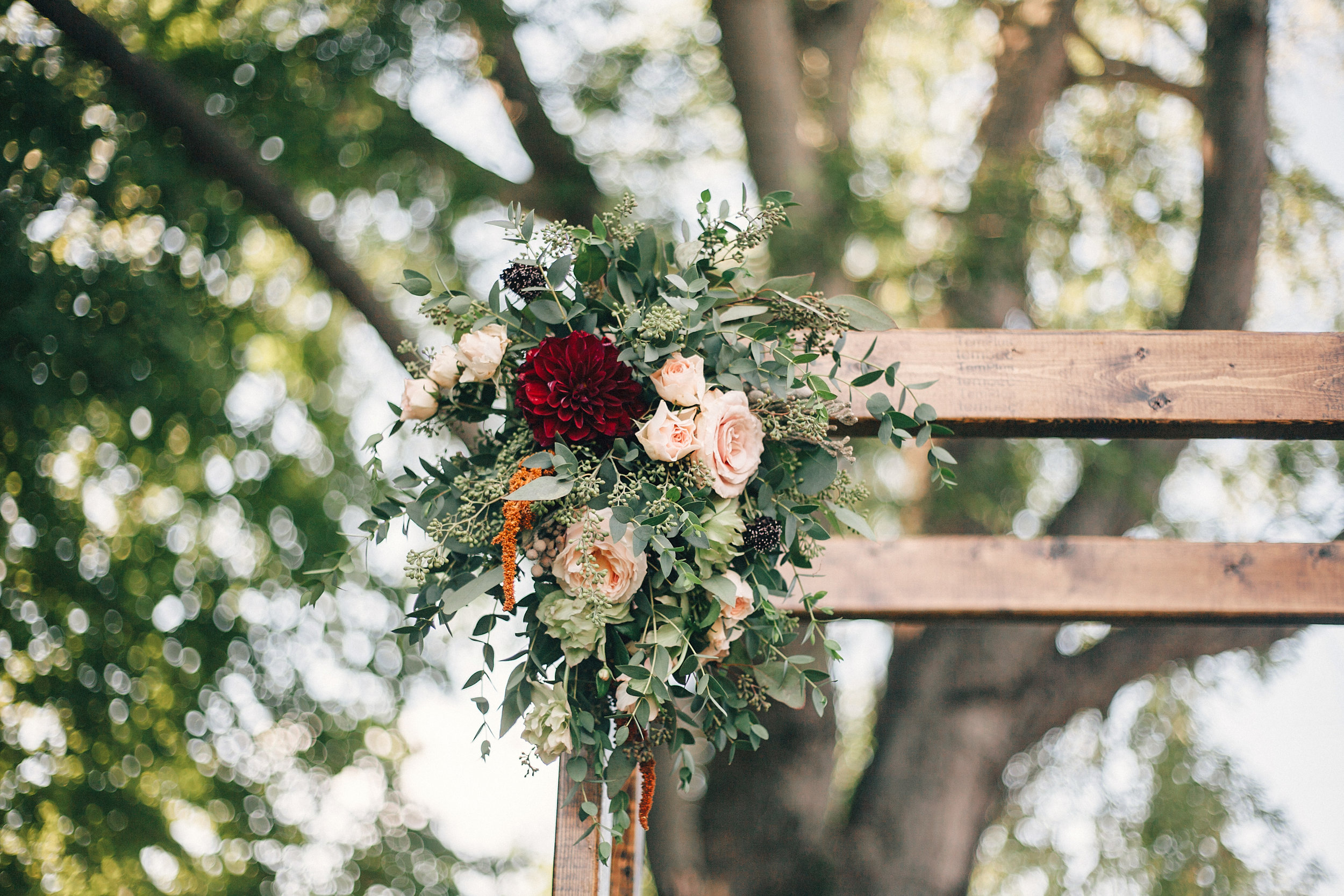 Simple chuppah style with loose greenery and pops of burgundy // Nashville Wedding Florist