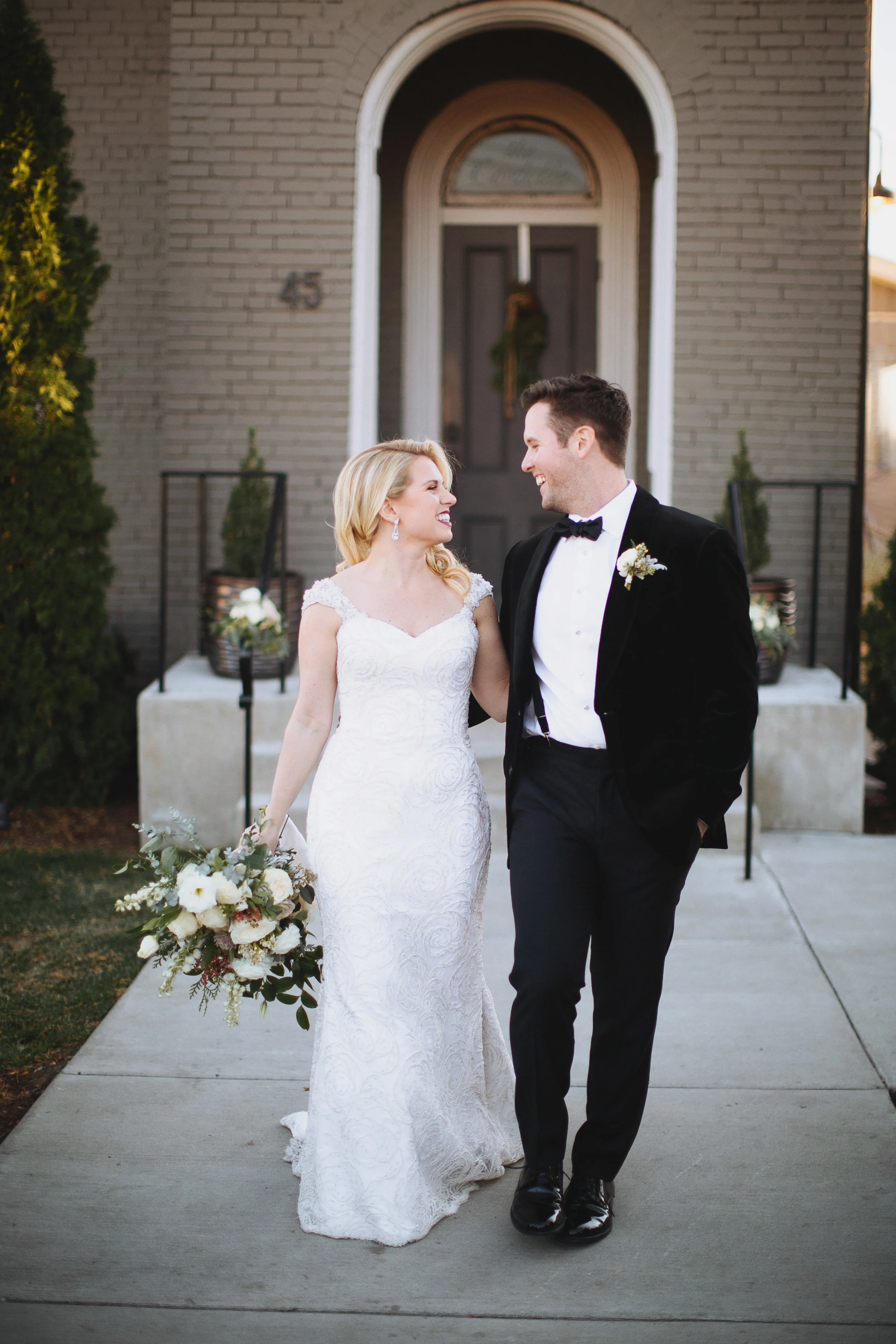 Wintry bridal bouquet with all white flowers, natural greenery, and touches of red berries // Nashville Wedding Florist