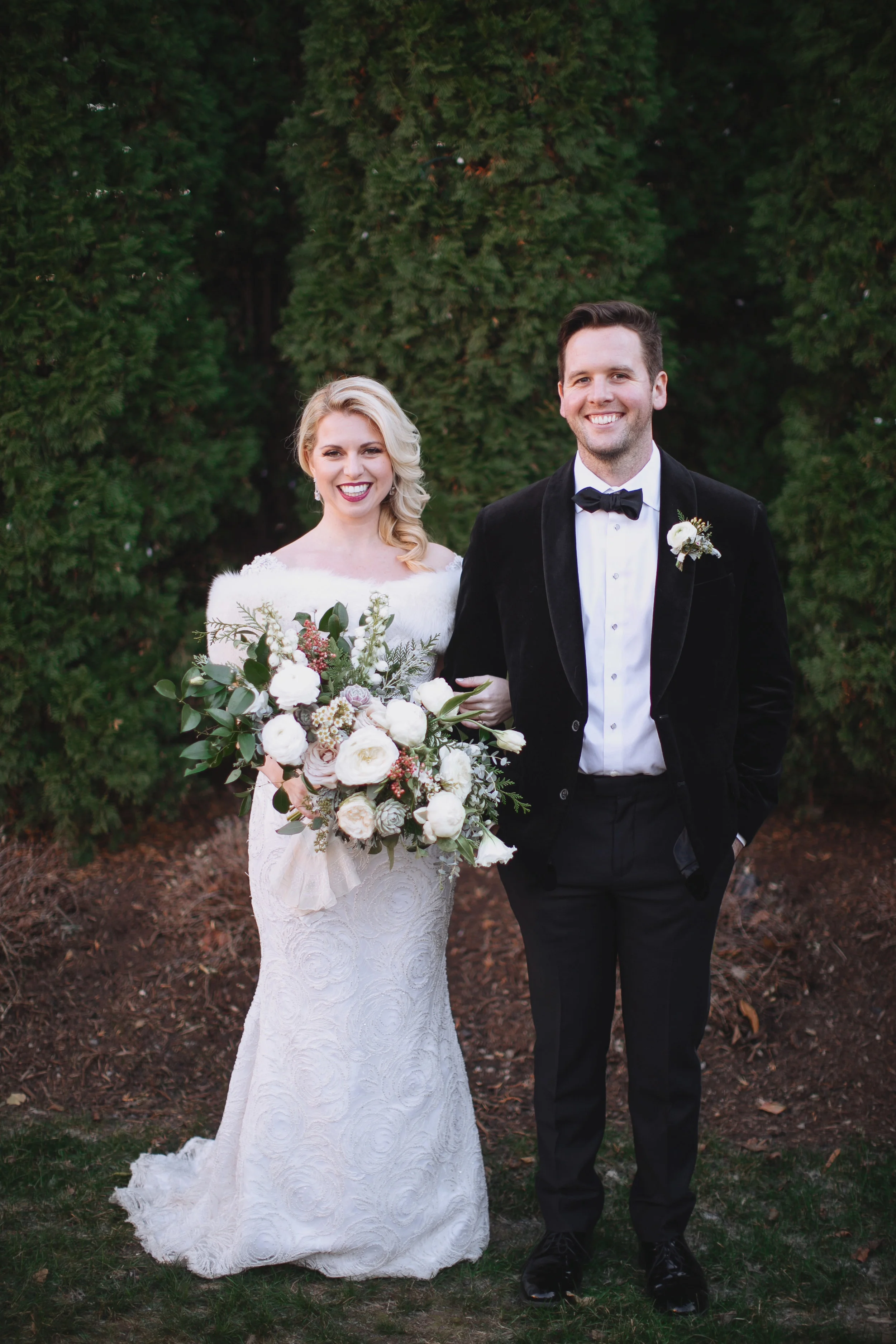Wintry bridal bouquet with all white flowers, natural greenery, and touches of red berries // Nashville Wedding Florist