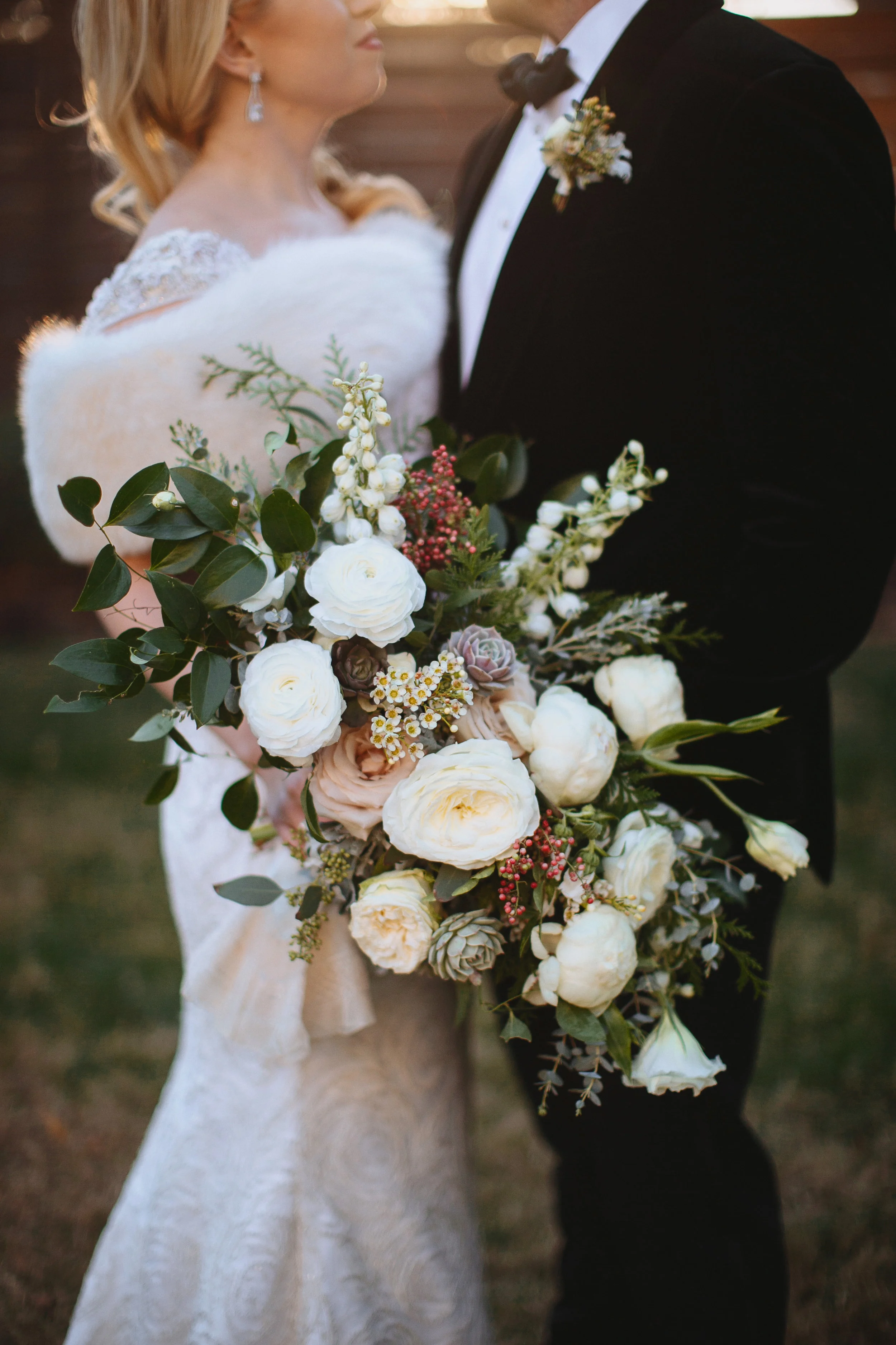 Wintry bridal bouquet with all white flowers, natural greenery, and touches of red berries // Nashville Wedding Florist