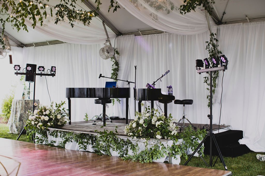 A smilax vine installation to set off the piano, along with statement arrangements filled with garden roses, white spray roses, ranunculus, and delphinium. Designed by florist Rosemary and Finch in Nashville, TN.