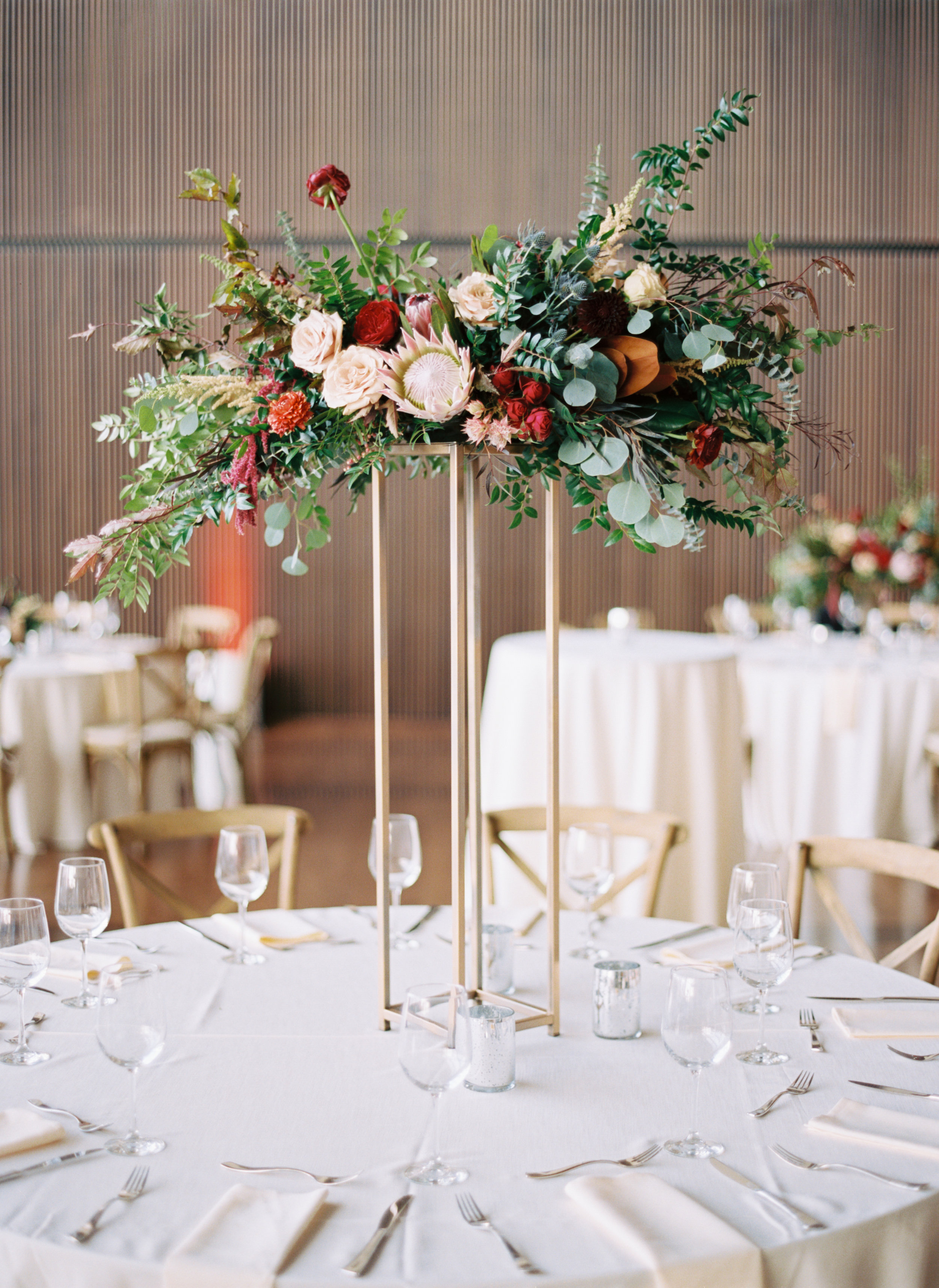 Blush and marsala centerpieces with protea, ranunculus, dahlias, and lush greenery // Country Music Hall of Fame Wedding, Nashville