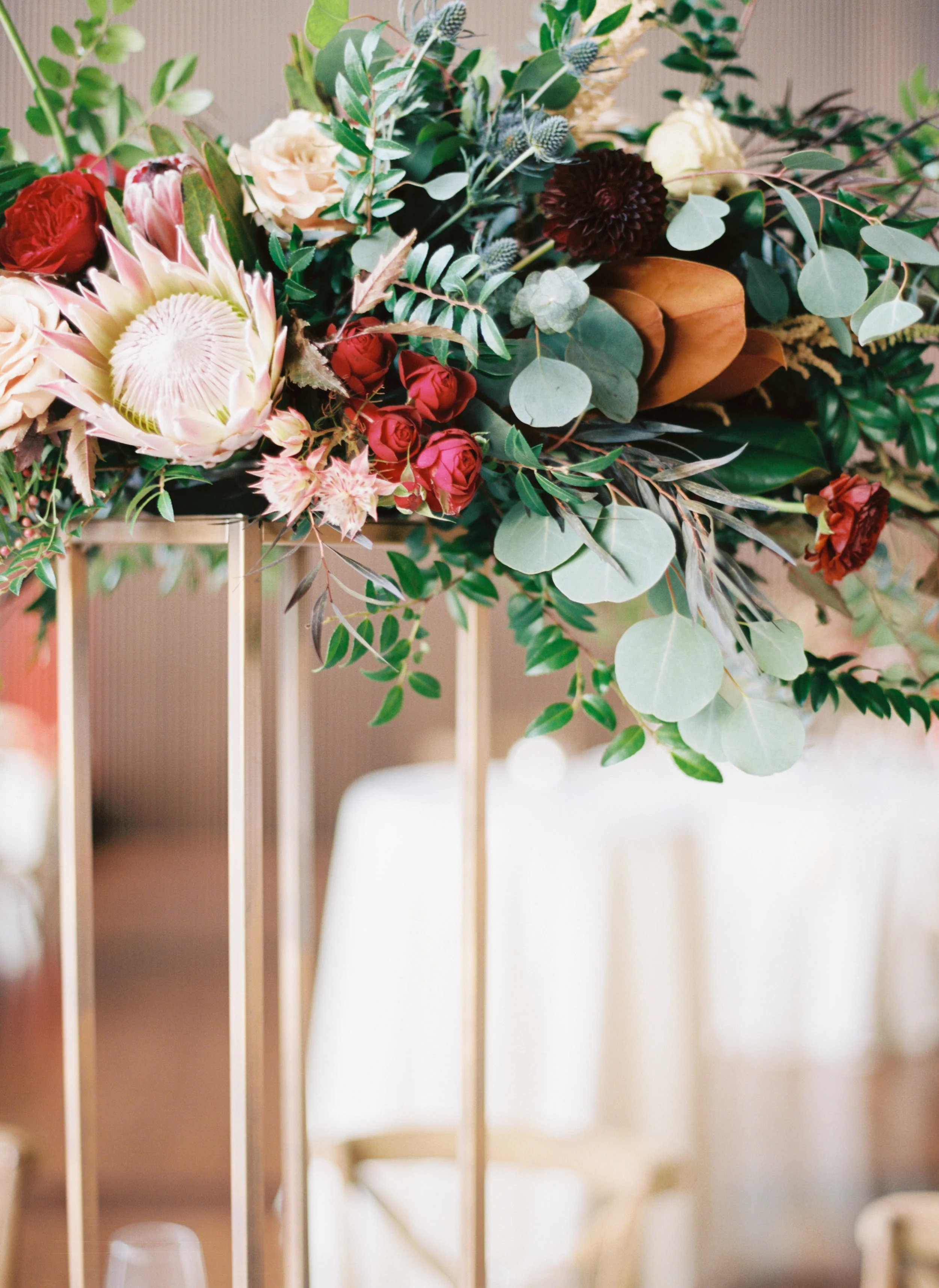 Blush and marsala centerpieces with protea, ranunculus, and lush greenery // Country Music Hall of Fame Wedding, Nashville