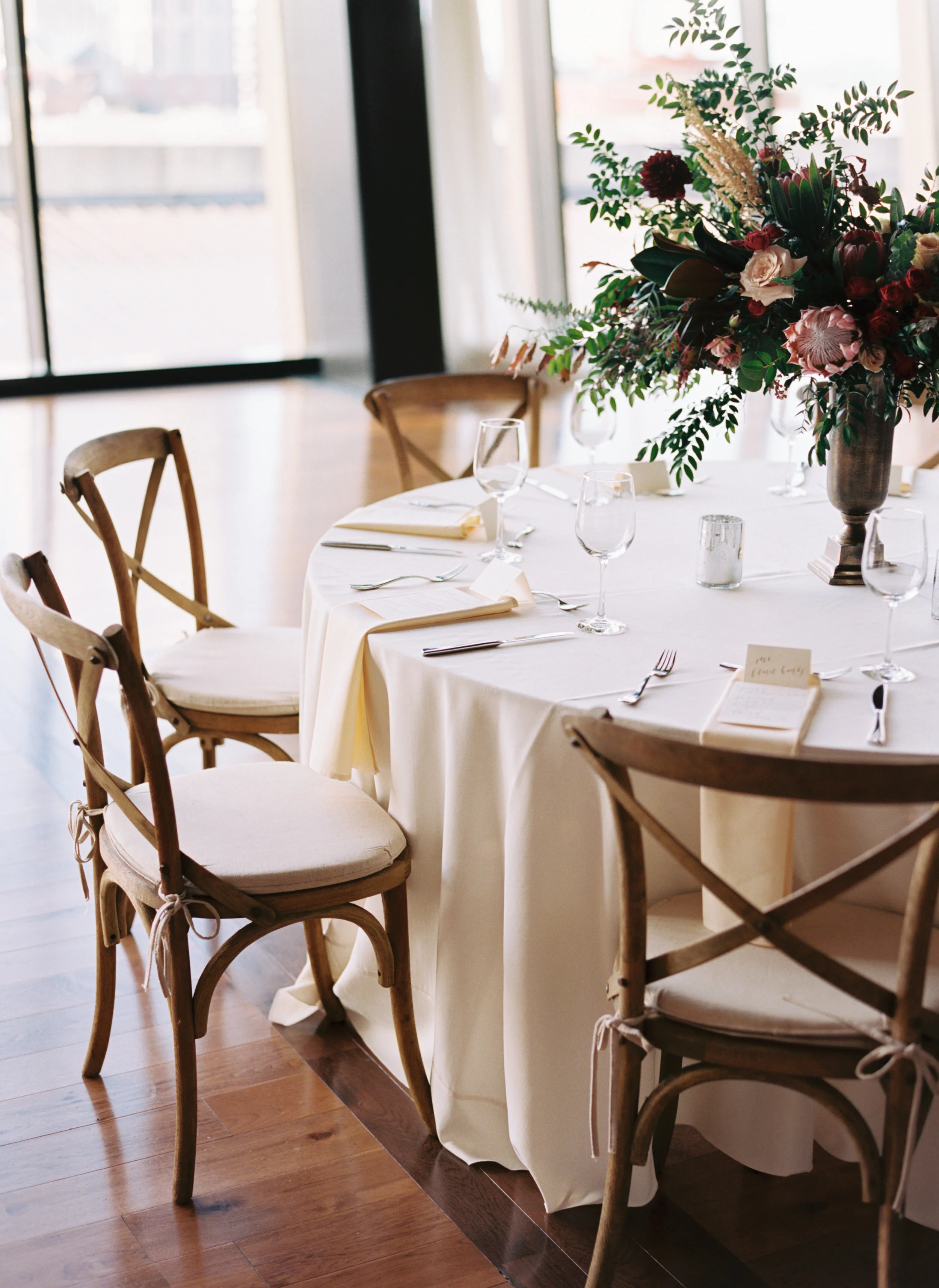 Centerpieces with marsala dahlias, burgundy ranunculus, peach astilbe, protea, and natural greenery // Nashville Wedding Florist // Country Music Hall of Fame