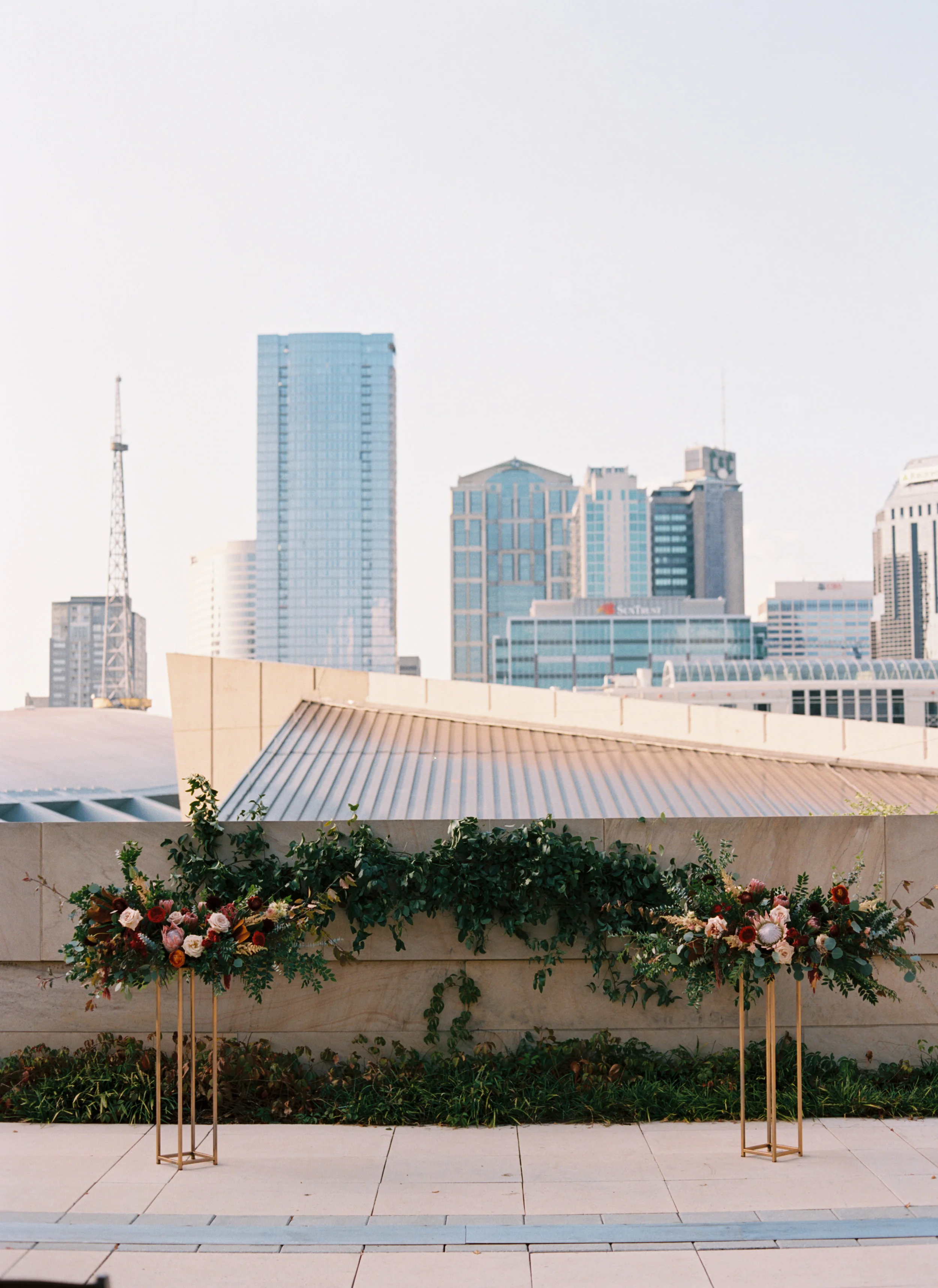 Centerpieces with marsala dahlias, burgundy ranunculus, peach astilbe, protea, and natural greenery // Nashville Wedding Florist // Country Music Hall of Fame