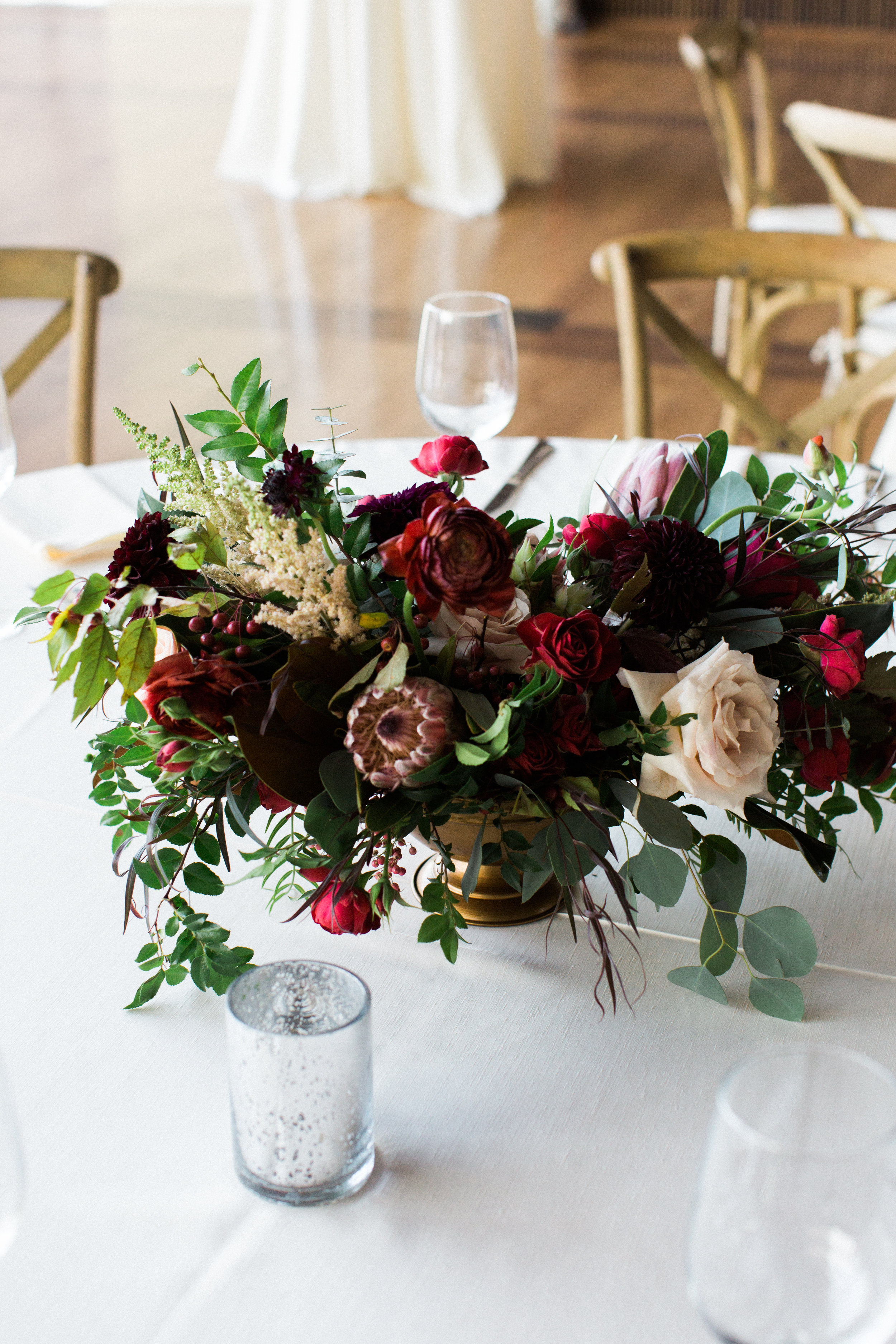 Centerpieces with marsala dahlias, burgundy ranunculus, peach astilbe, protea, and natural greenery // Nashville Wedding Florist // Country Music Hall of Fame