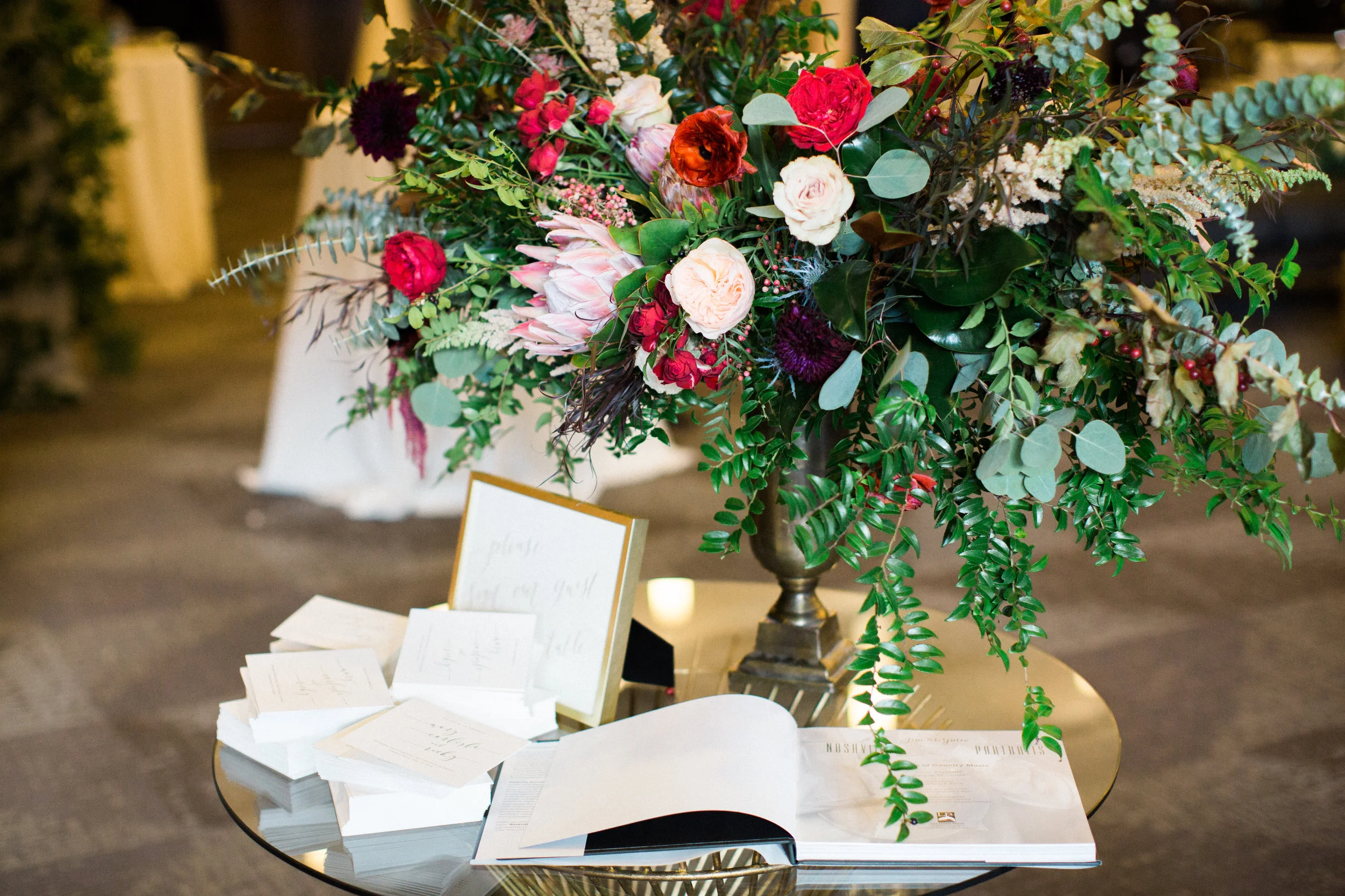 Lush, untamed elevated centerpiece with king protea, marsala dahlias, soft peach astilbe, and natural greenery // Nashville Wedding Floral Design