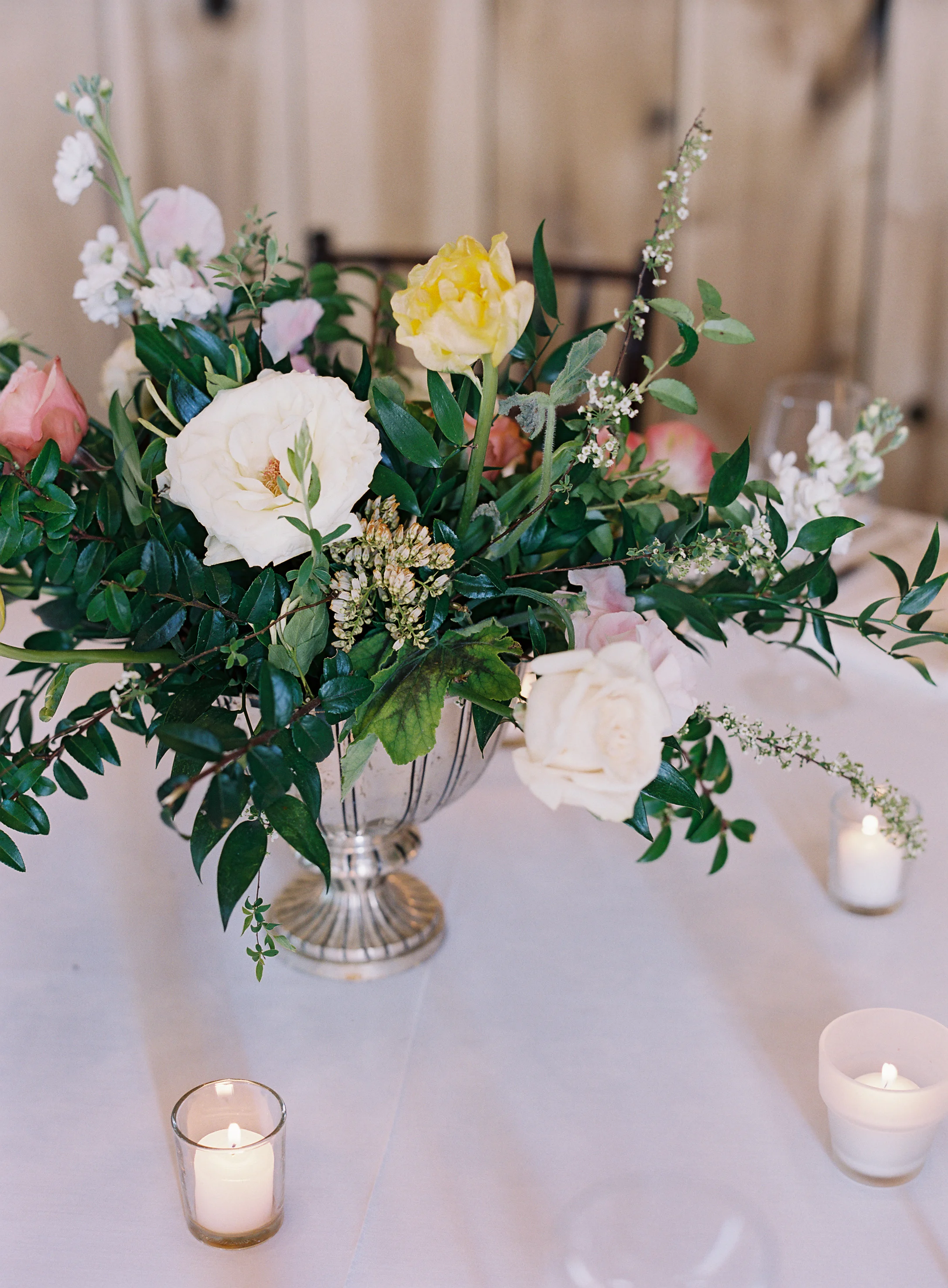 Silver compote centerpieces with natural greenery, peach garden roses, pink tulips, and spirea // Nashville Wedding Floral Design