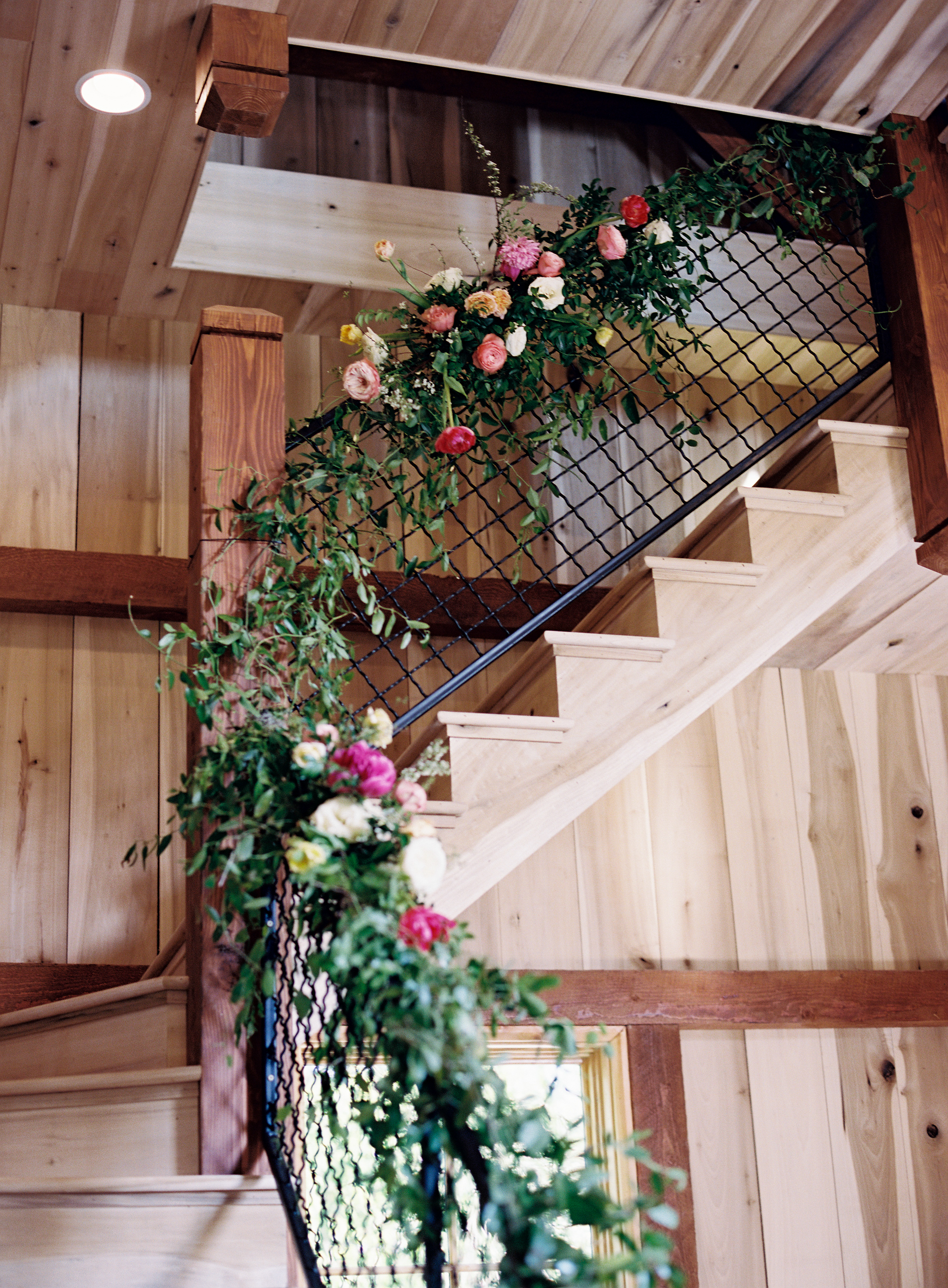 Stairwell garland with bright floral accents // Nashville Barn Wedding Florist