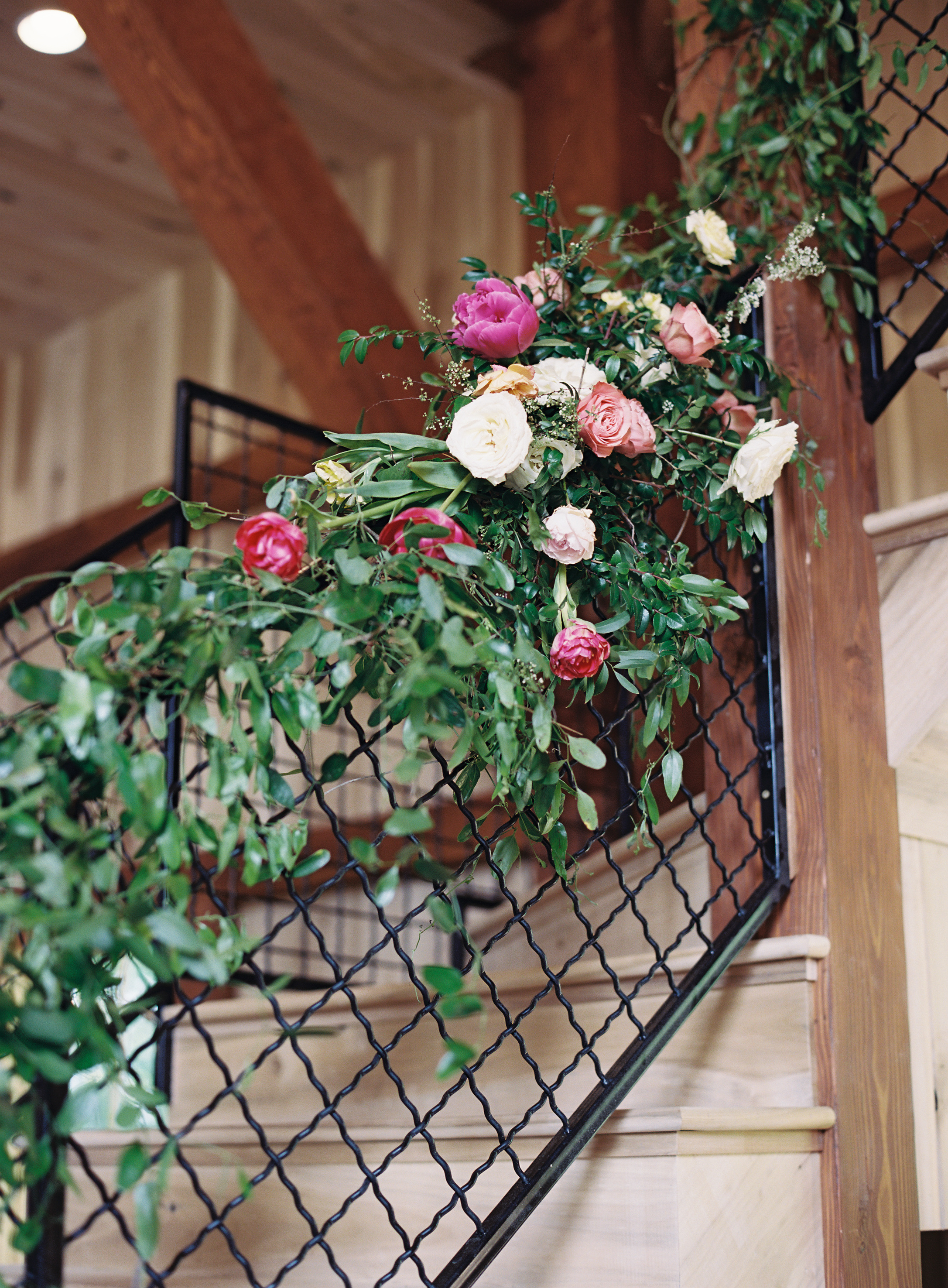 Lush vines trailing down the stairwell with pink and peach floral pops // Nashville Wedding Floral Design