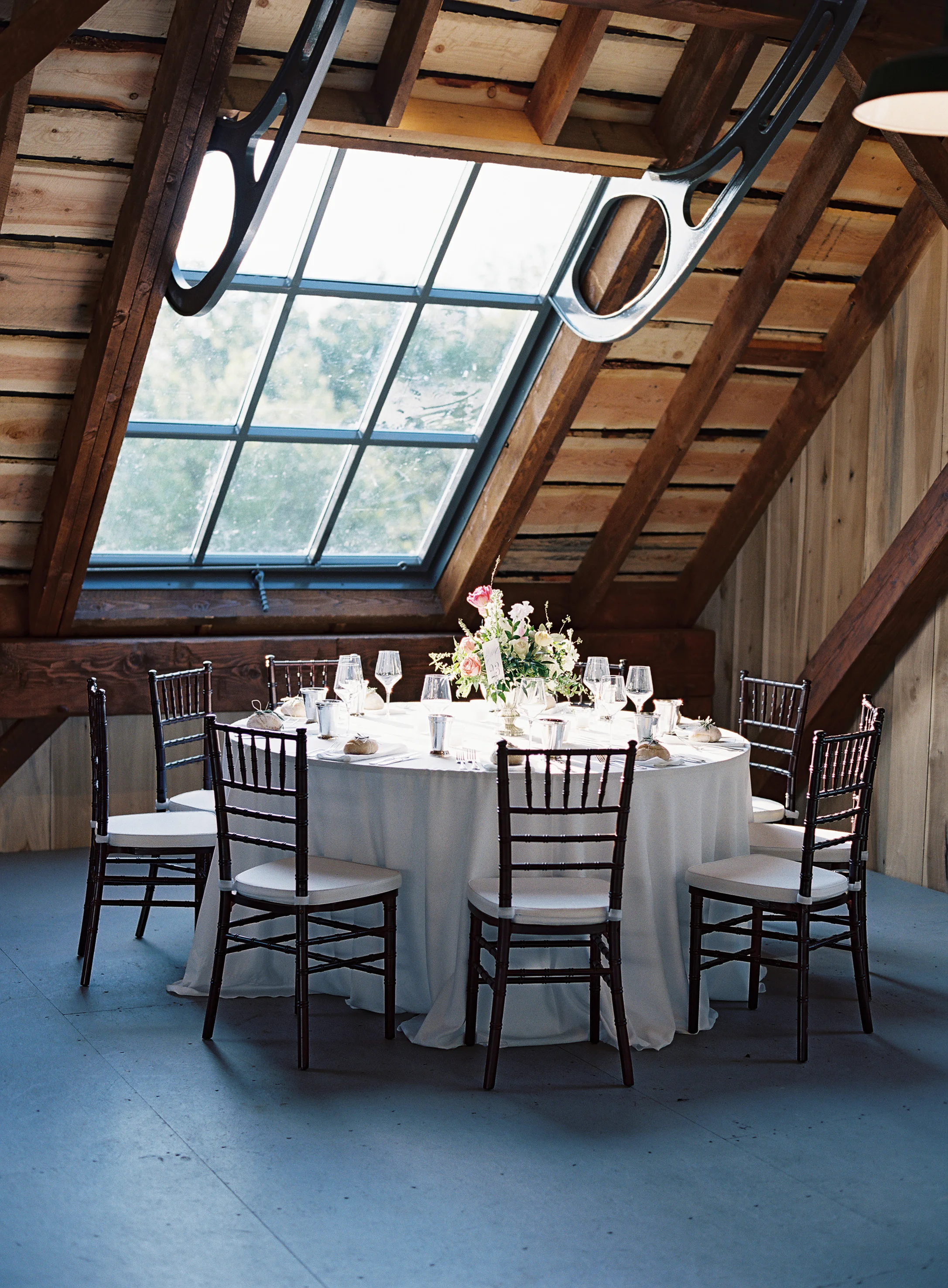 Loft seating for guests // Silver compote centerpieces with natural greenery, peach garden roses, pink tulips, and spirea // Nashville Wedding Floral Design