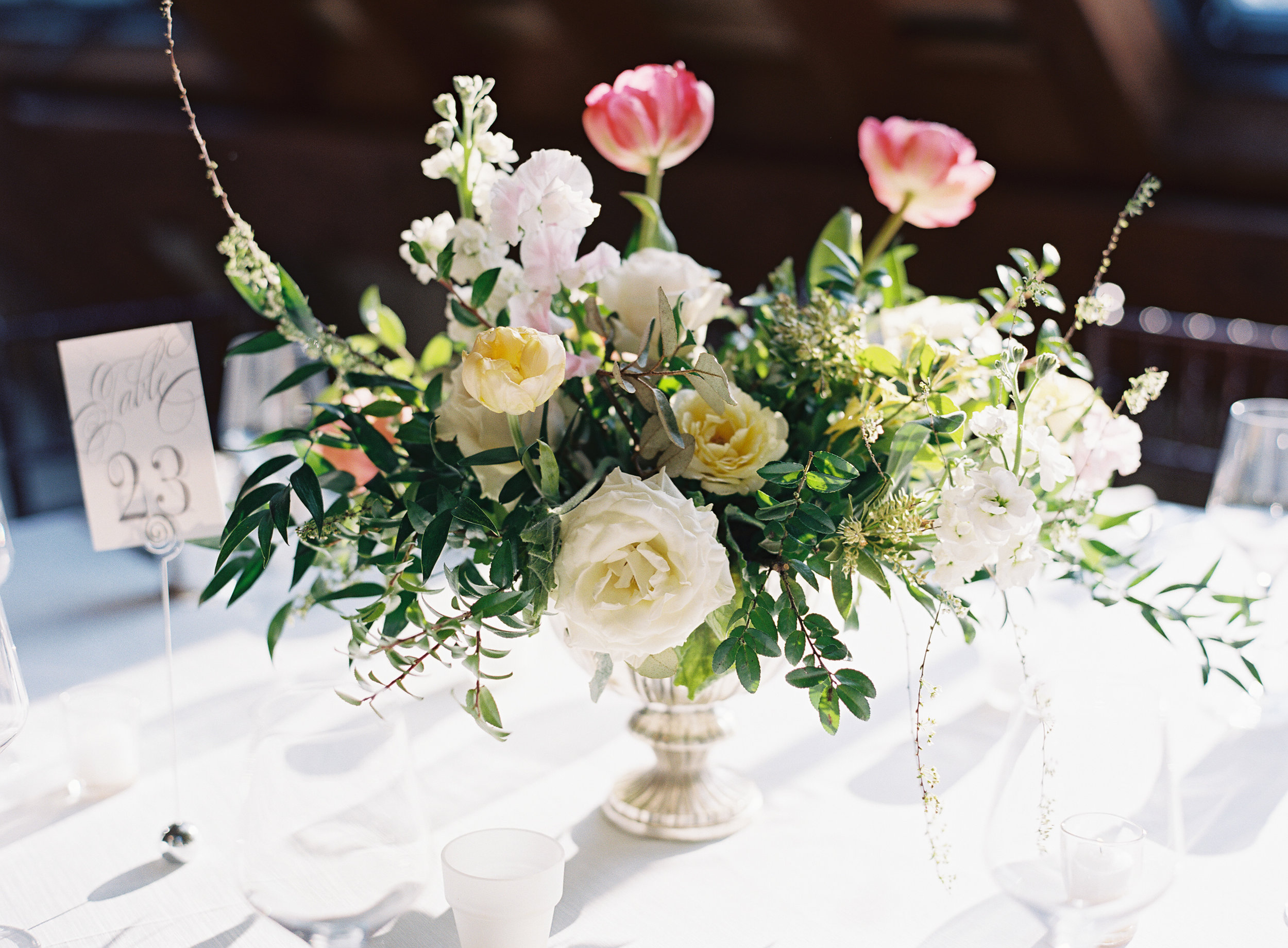 Silver compote centerpieces with natural greenery, peach garden roses, pink tulips, and spirea // Nashville Wedding Floral Design