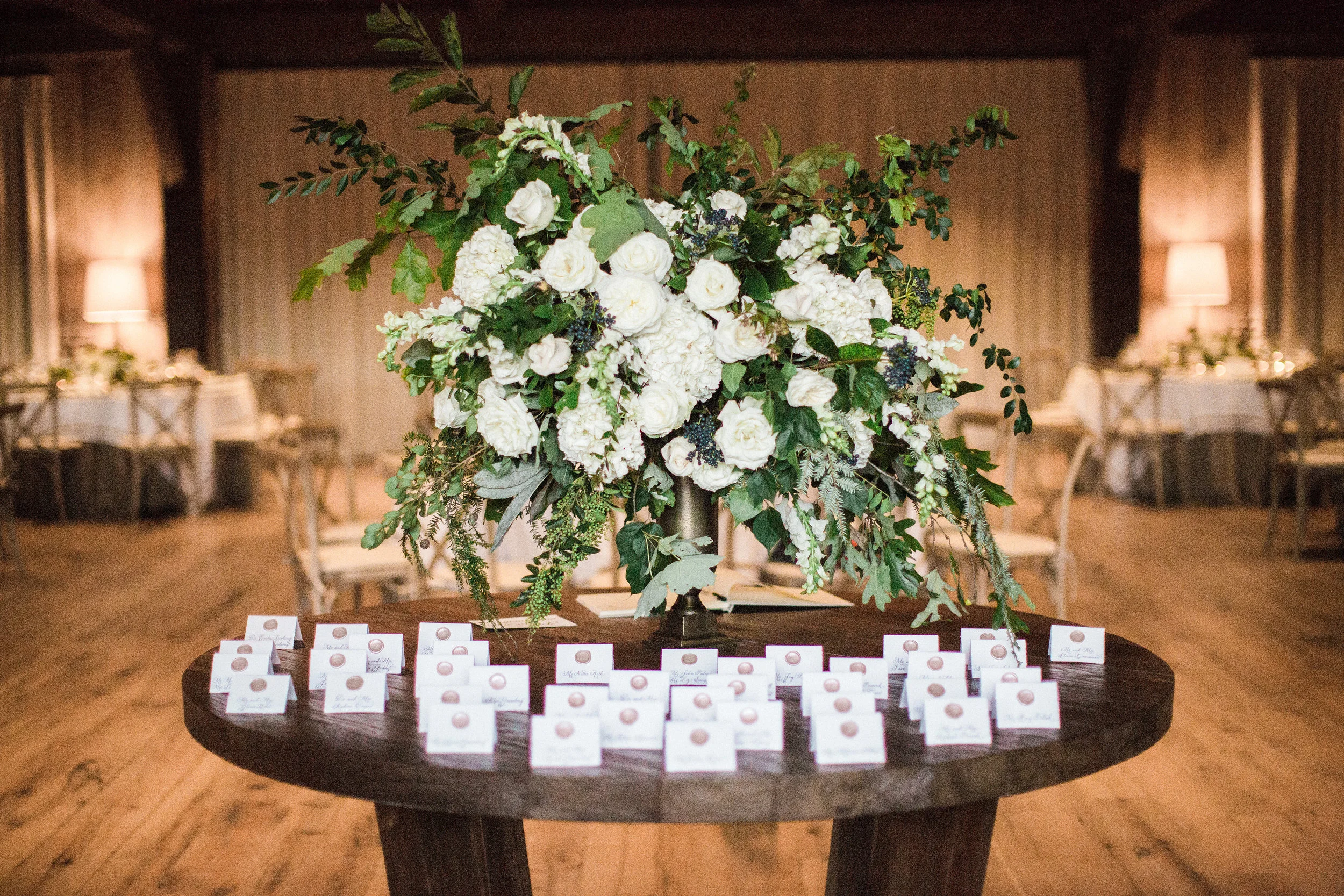 Large, asymmetrical floral arrangement with white flowers and untamed greenery and berries // Blackberry Farm Wedding Floral Design